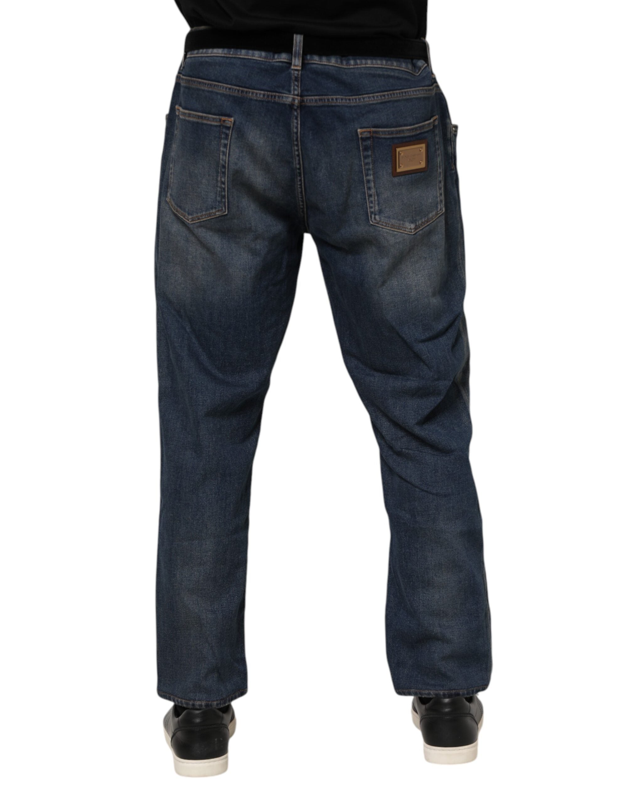 Jeans slim en denim bleu Dolce & Gabbana avec plaque logo en coton, détail de la coupe et du design tendance.