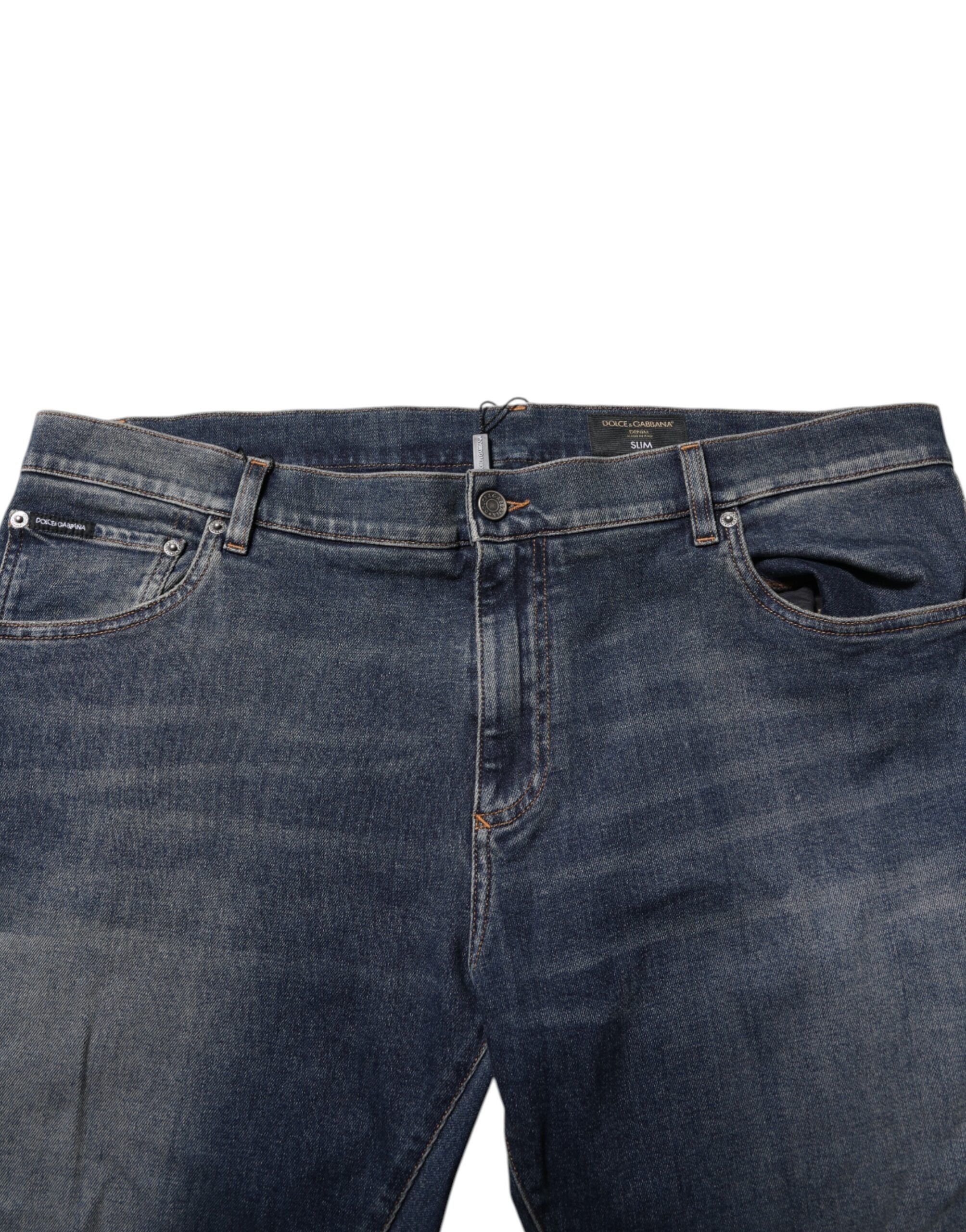 Jeans slim en denim bleu Dolce & Gabbana avec logo en plaque en coton, détails modernes et coupe ajustée.
