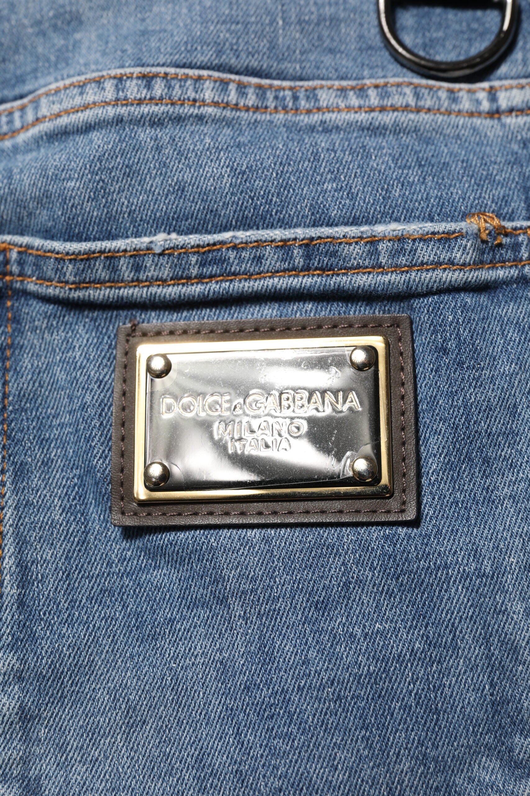Jeans skinny en denim bleu Dolce & Gabbana avec déchirures, logo brodé, coupe ajustée et style décontracté.