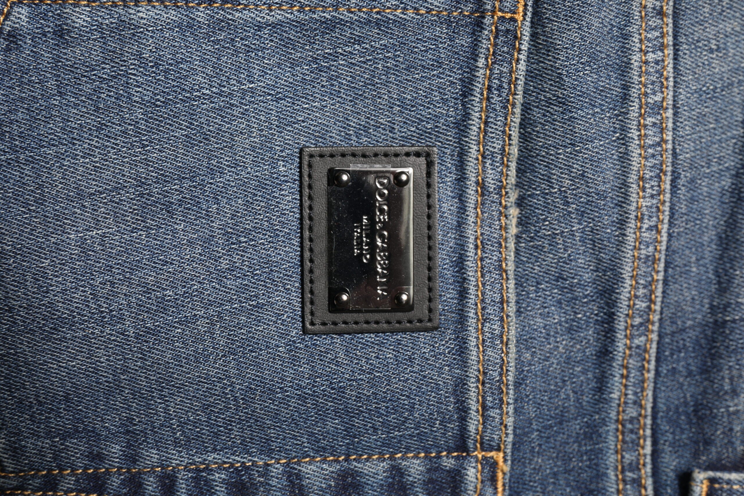 Jeans homme Dolce & Gabbana bleu délavé skinny avec logo et plaque en denim, style moderne et élégant.