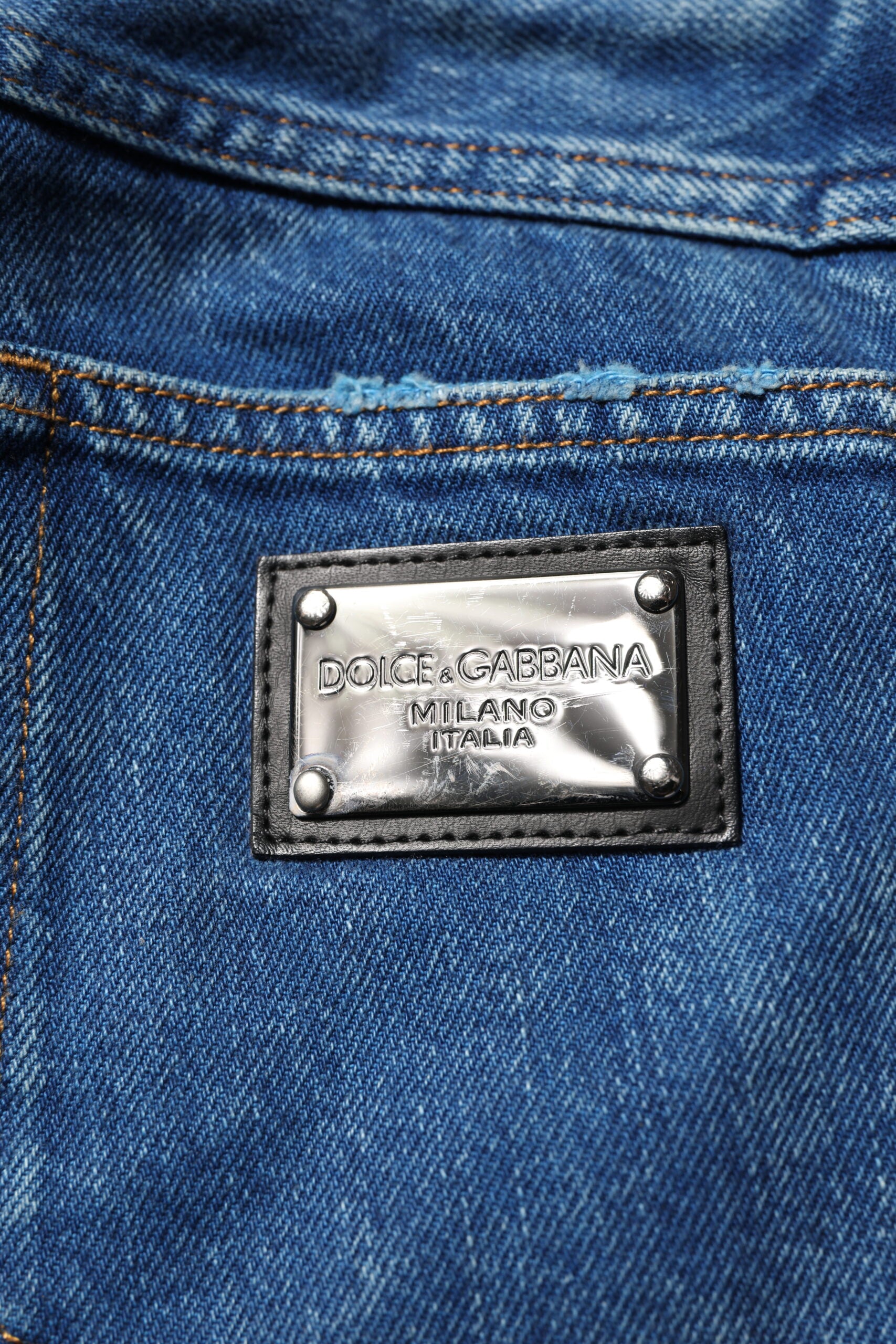 Jeans en denim Dolce & Gabbana bleu avec logo en plaque en coton, style décontracté et détails classiques.