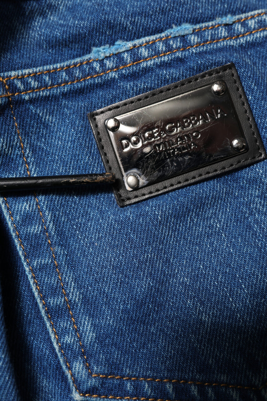 Jeans en denim bleu Dolce & Gabbana avec plaque logo en coton, style décontracté et tendance.