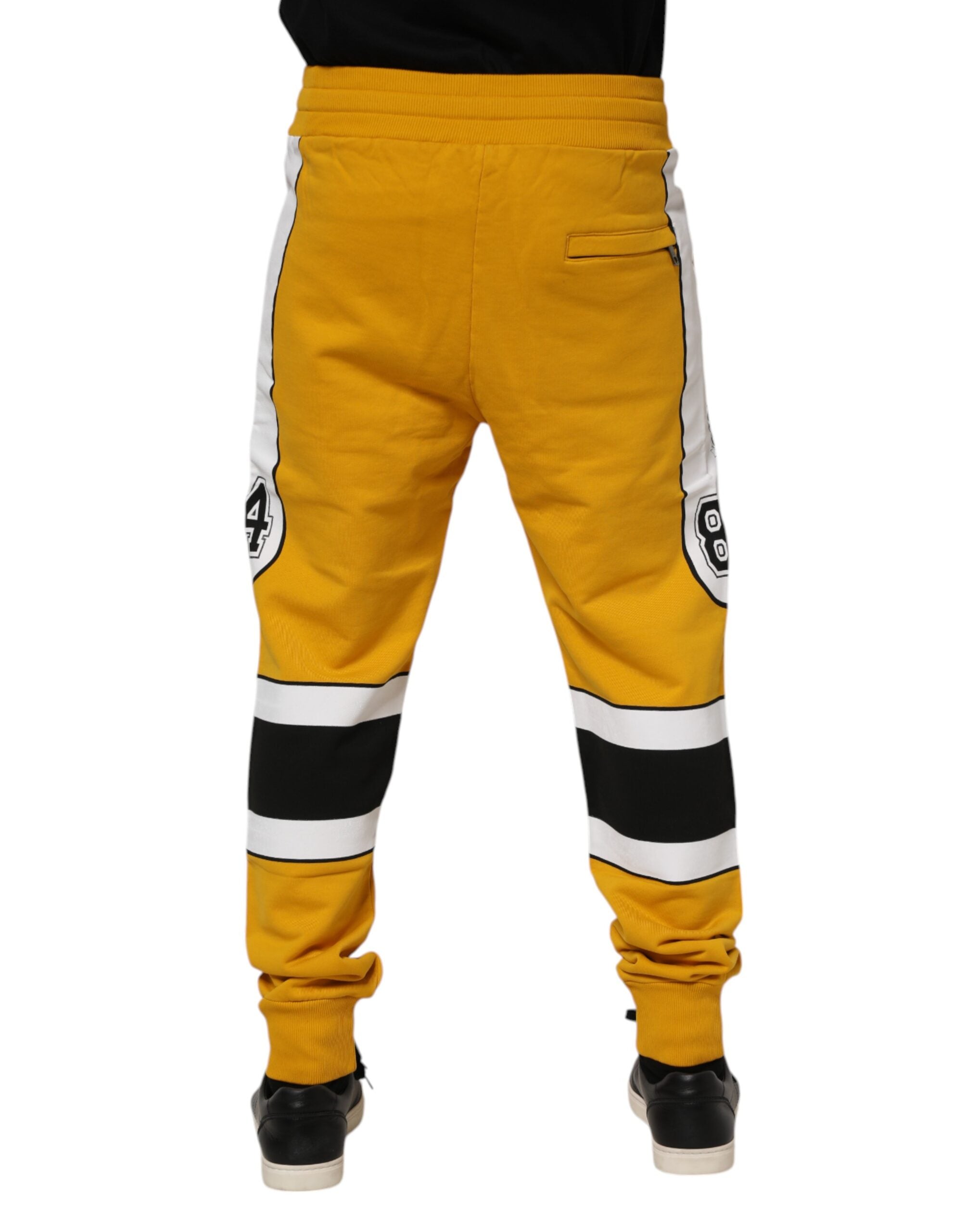 Pantalons de jogging en coton jaune Dolce & Gabbana avec logo, style décontracté et confortable, visibles en détail dans l'image.