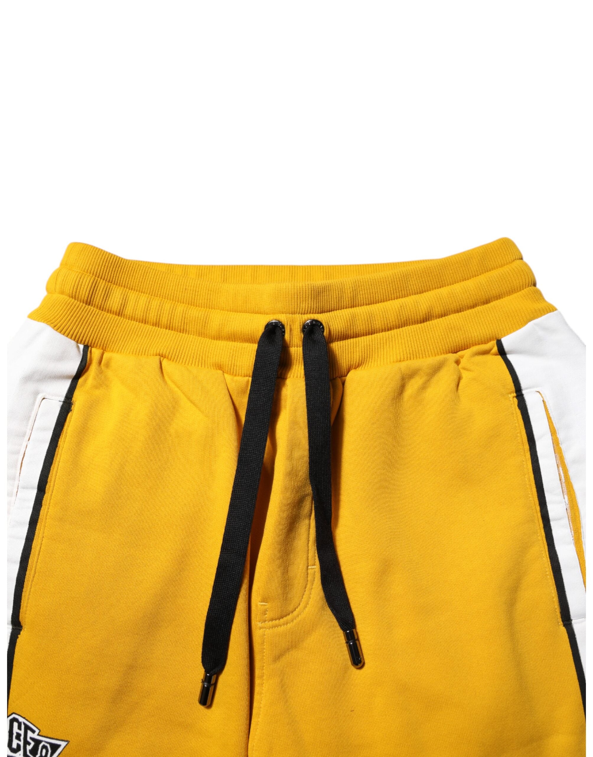Pantalon jogger Dolce & Gabbana en coton jaune avec logo, style décontracté et confortable, visible sur l'image.