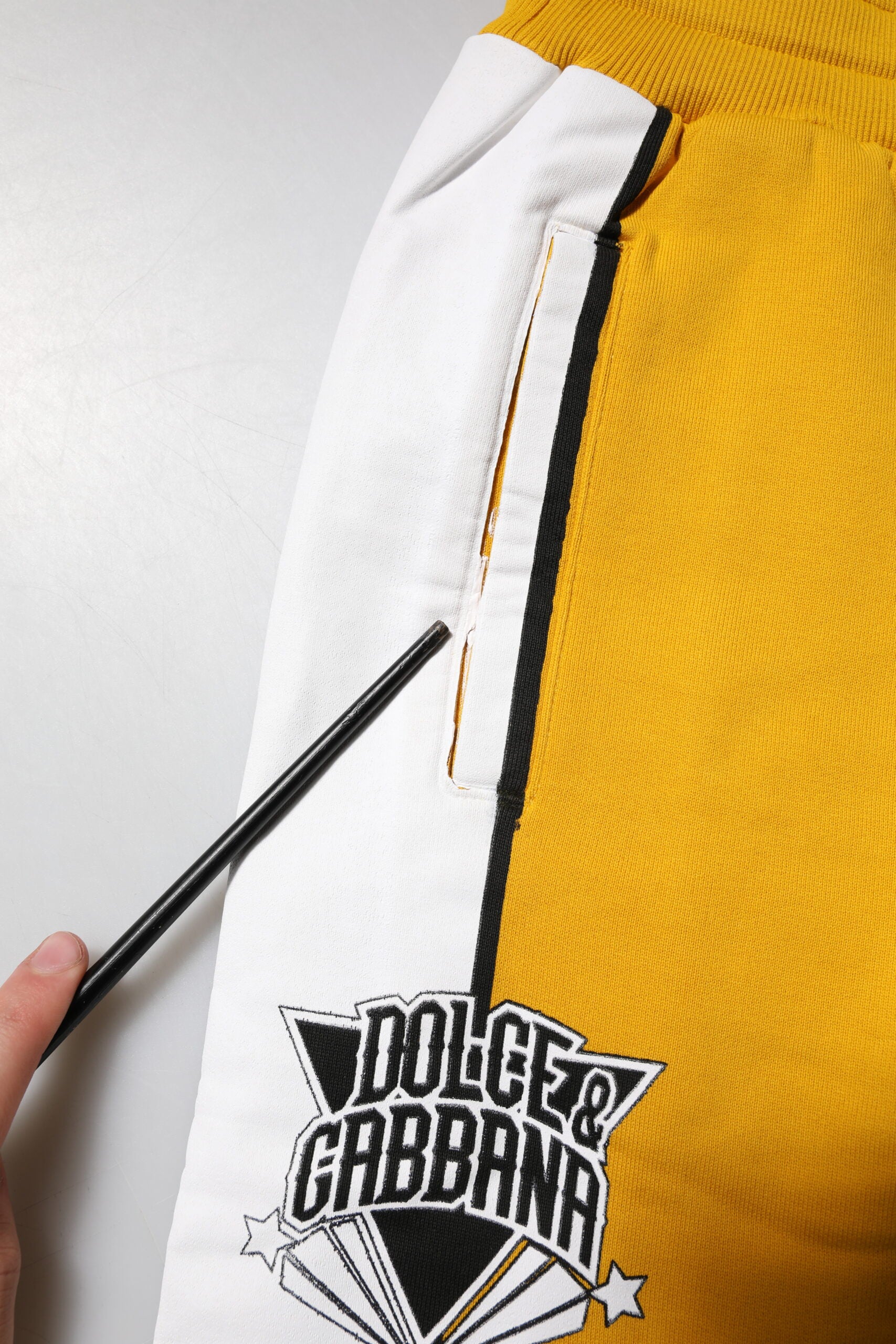 Pantalons jogger jaunes imprimés avec corde de serrage de la marque Dolce & Gabbana, vue de face.