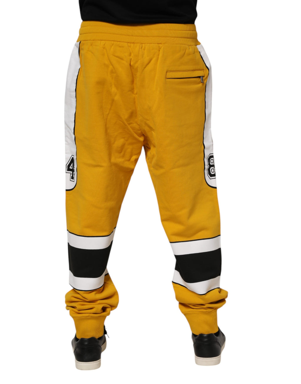Pantalon jogger en coton jaune Dolce & Gabbana avec logo, cordons de serrage, style décontracté, visible avec poches latérales.