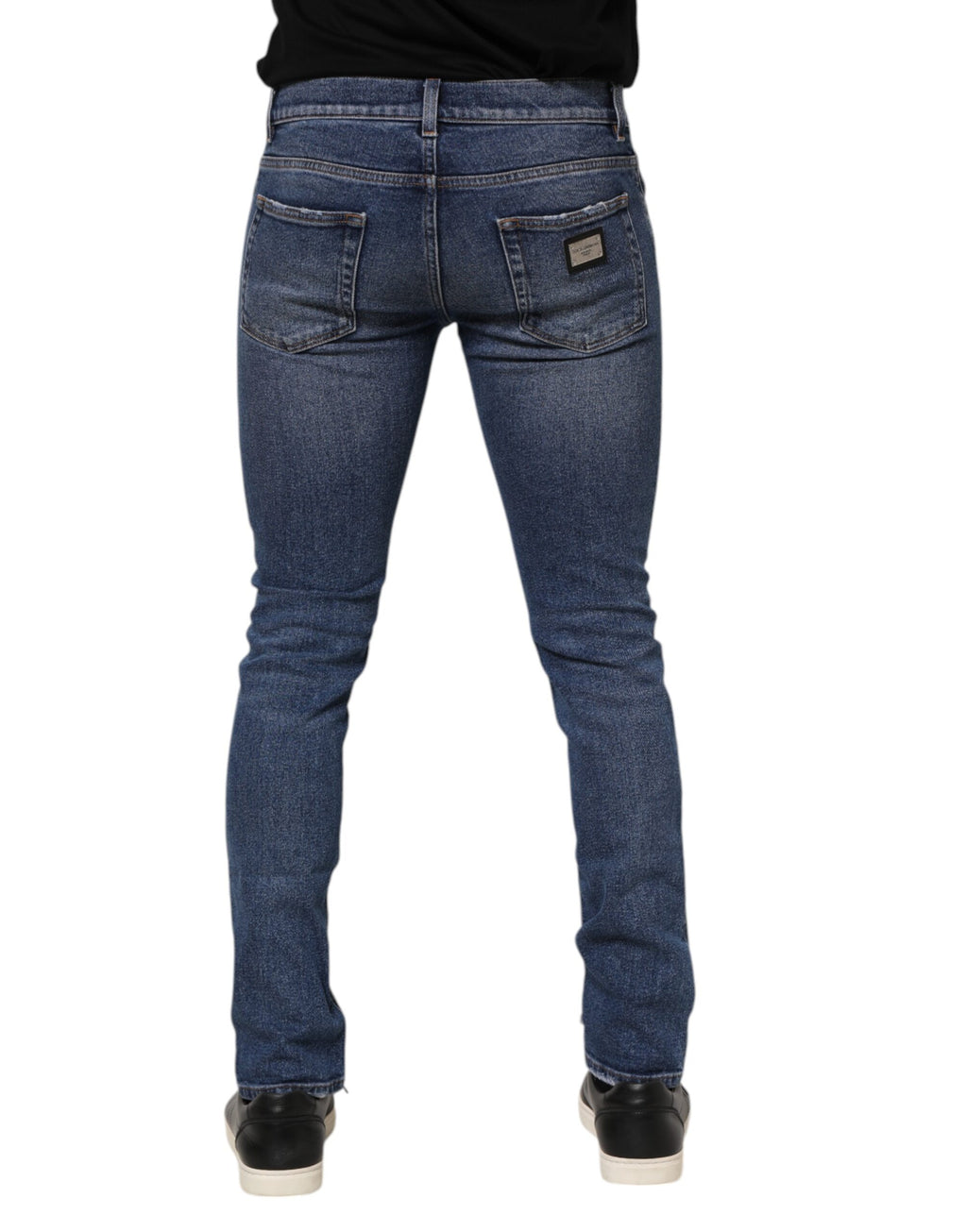 Jeans homme en denim bleu Dolce & Gabbana avec logo en plaque, coupe skinny et détails élégants.