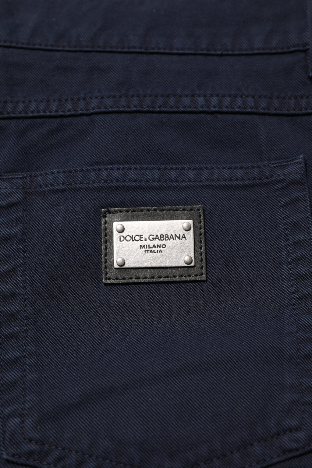 Jeans en denim noir Dolce & Gabbana, coupe tapered, en coton, visibles avec détails de couture et fermeture éclair.