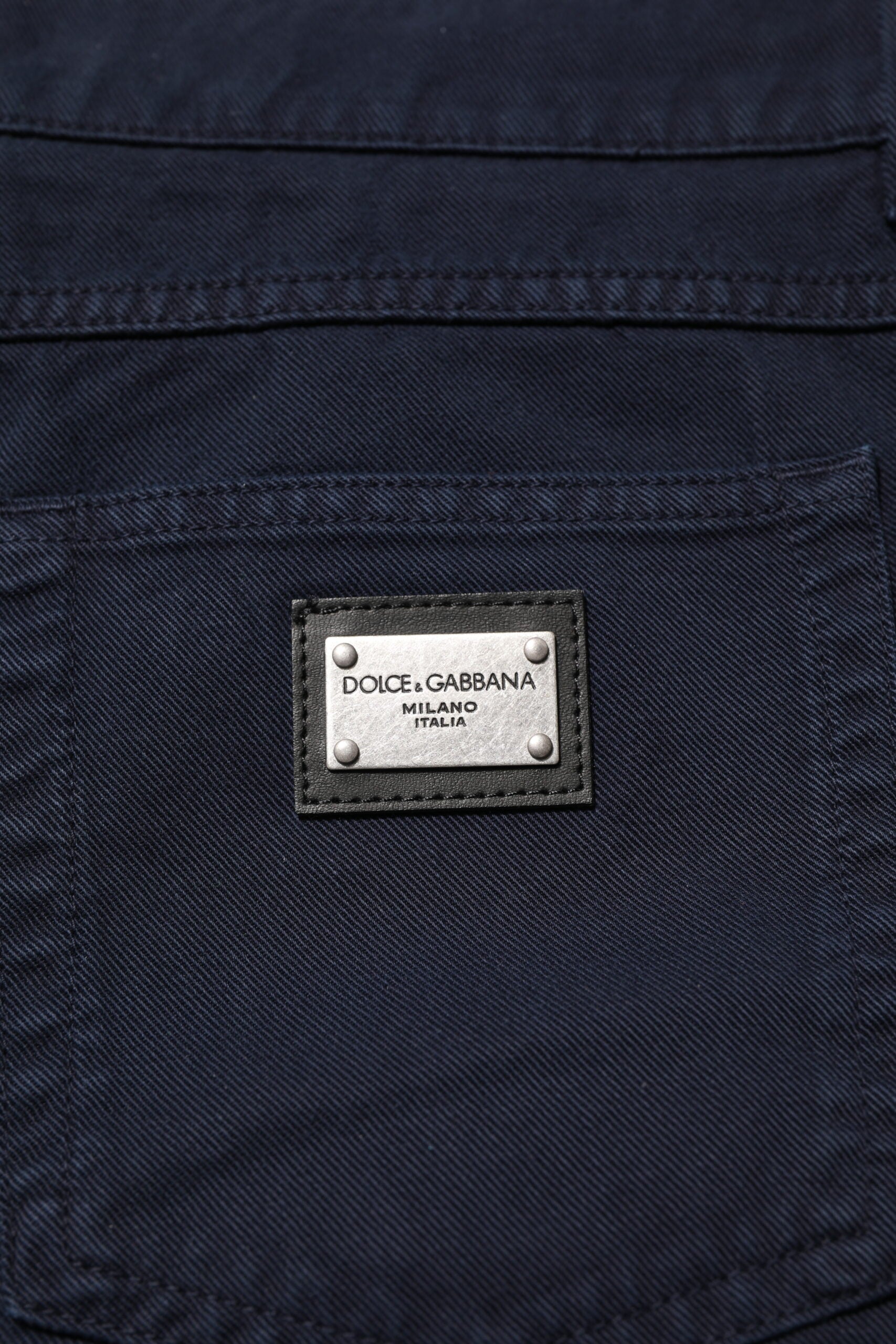 Jeans en denim noir Dolce & Gabbana, coupe tapered, en coton, visibles avec détails de couture et fermeture éclair.