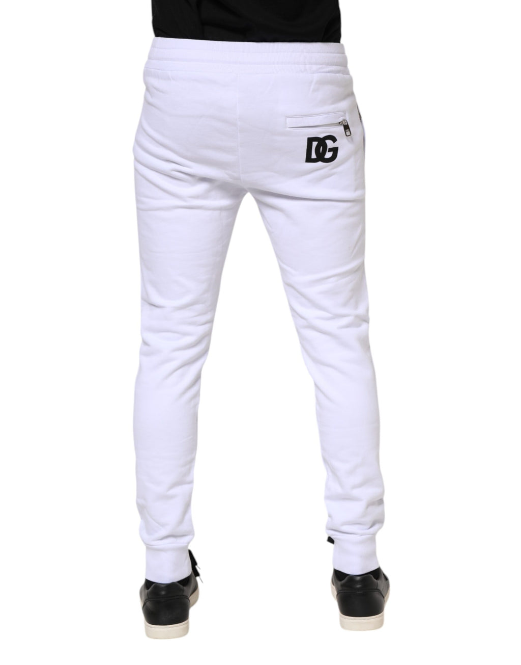 Pantalons jogger en coton blanc Dolce & Gabbana avec cordon de serrage, style décontracté et moderne, visibles en gros plan dans l'image.