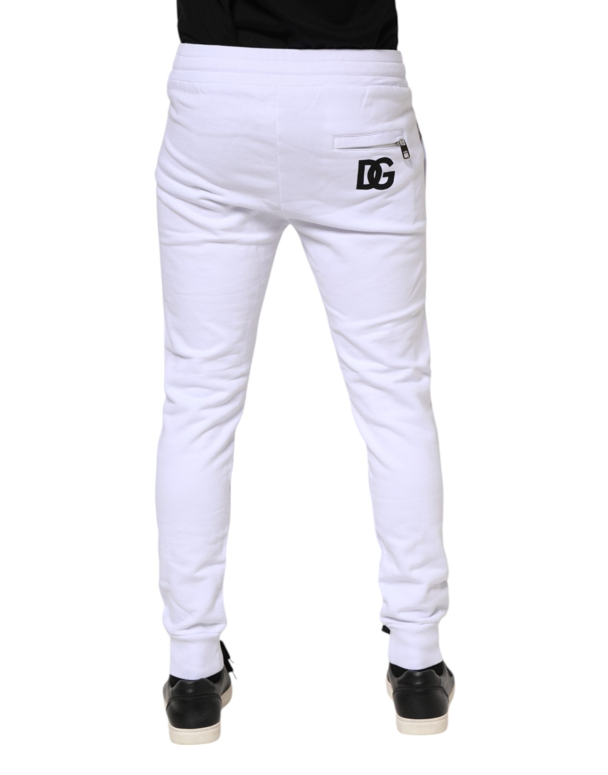 Pantalons jogger en coton blanc Dolce & Gabbana avec cordon de serrage, style décontracté et moderne, visibles en gros plan dans l'image.