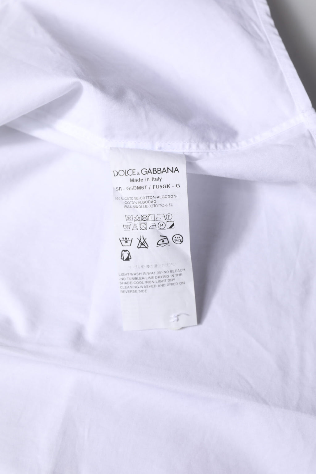 Chemise formelle blanche en coton Dolce & Gabbana avec manches longues et détails dorés sur le col et les poignets.