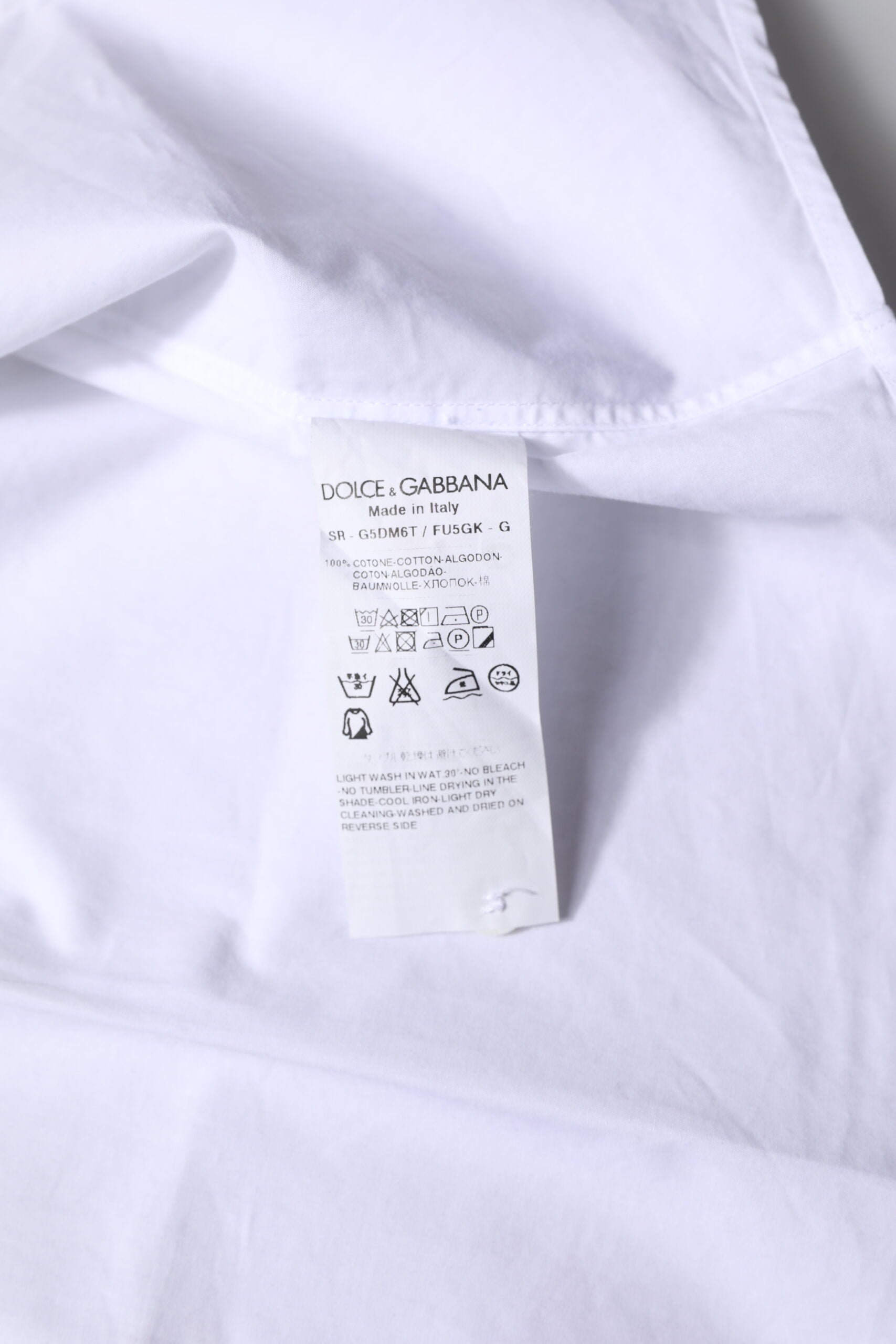 Chemise formelle blanche en coton Dolce & Gabbana avec manches longues et détails dorés sur le col et les poignets.