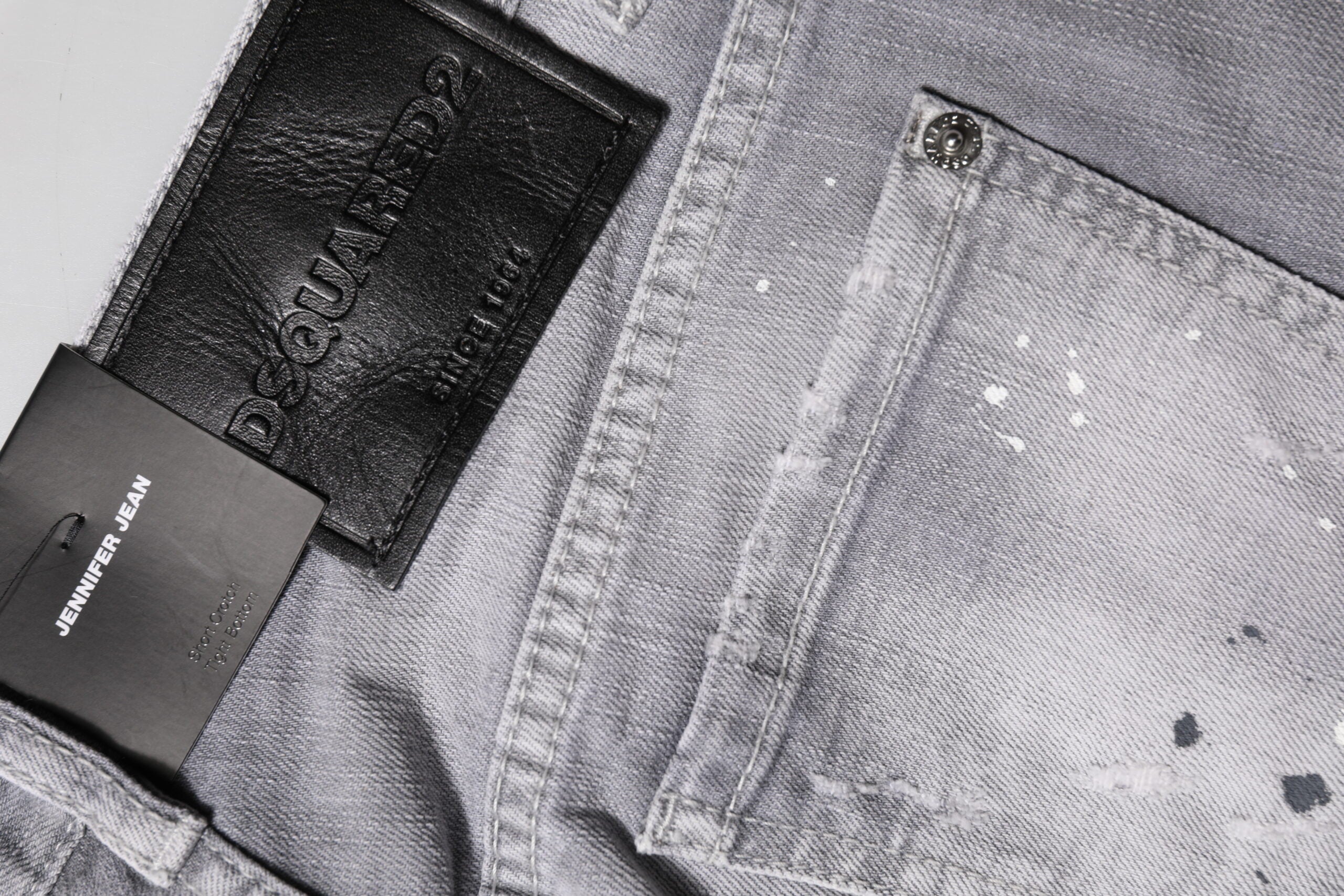 Jeans en denim gris délavé, coupe ajustée à la taille moyenne, de la marque Dsquared², visibles sur l'image.