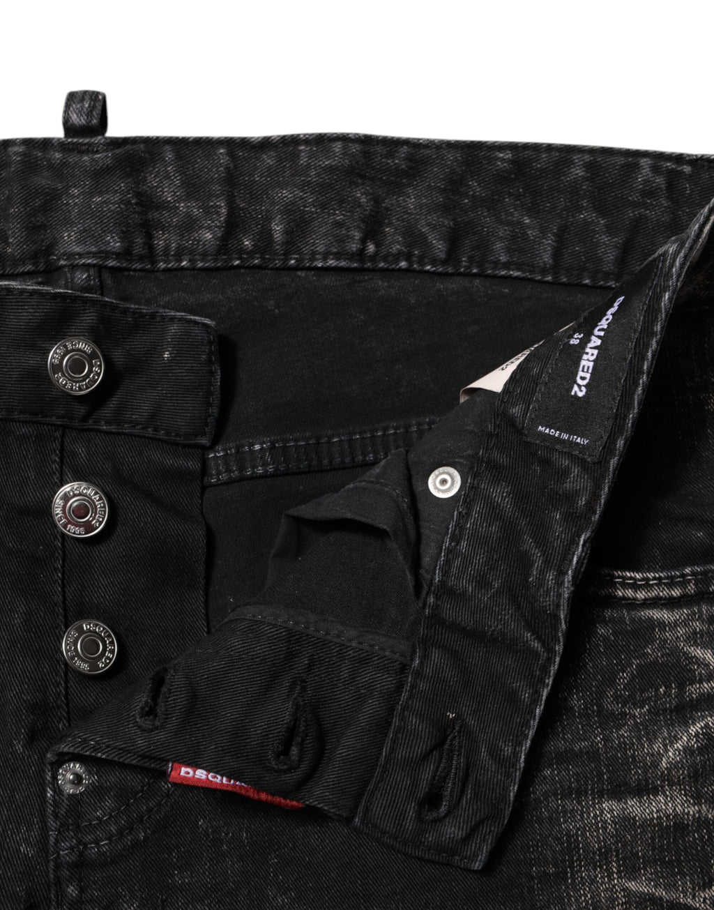 Jeans en denim noir délavé, coupe tapered à taille moyenne, de la marque Dsquared², affichés sur un fond neutre.