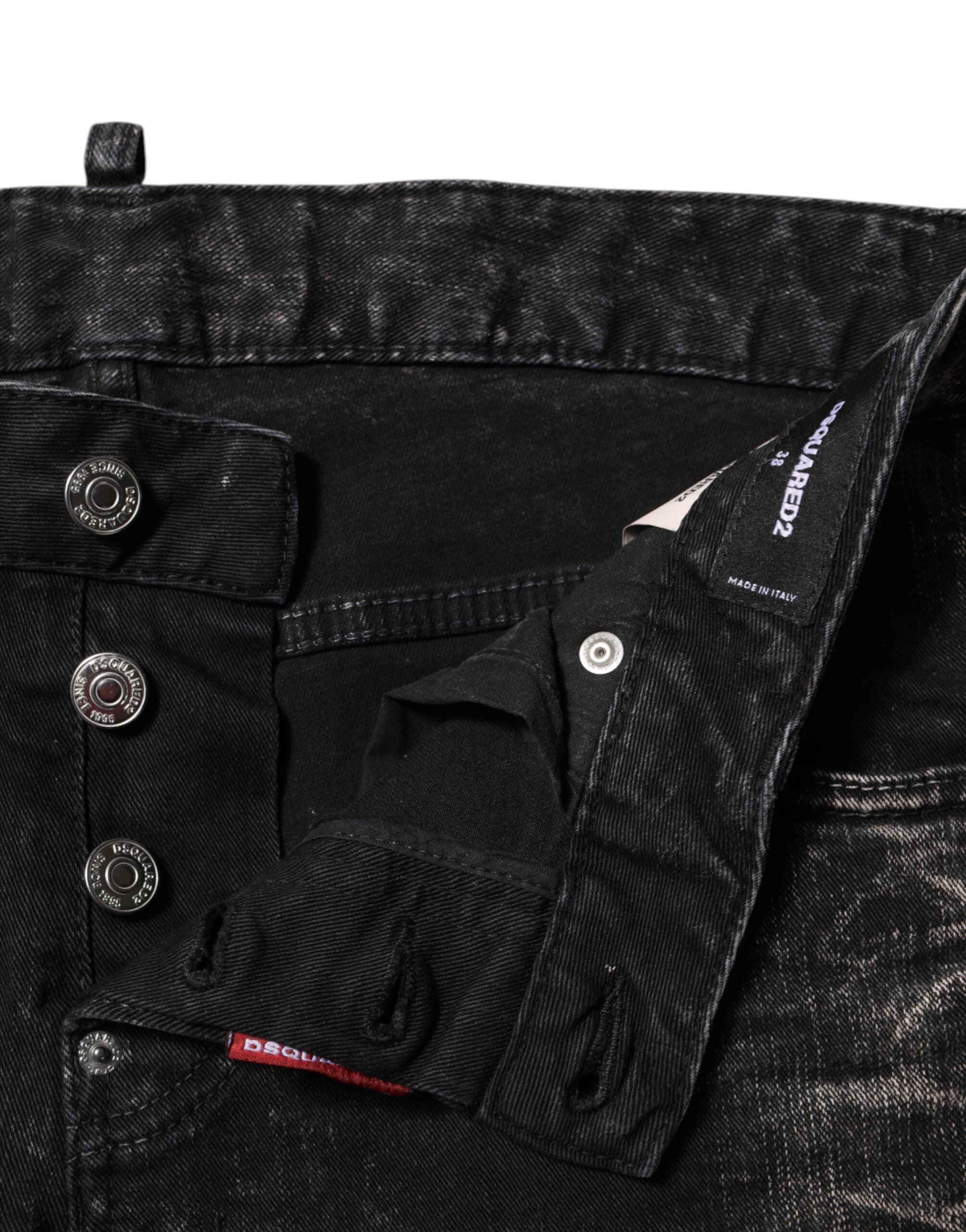 Jeans en denim noir délavé, coupe tapered à taille moyenne, de la marque Dsquared², affichés sur un fond neutre.