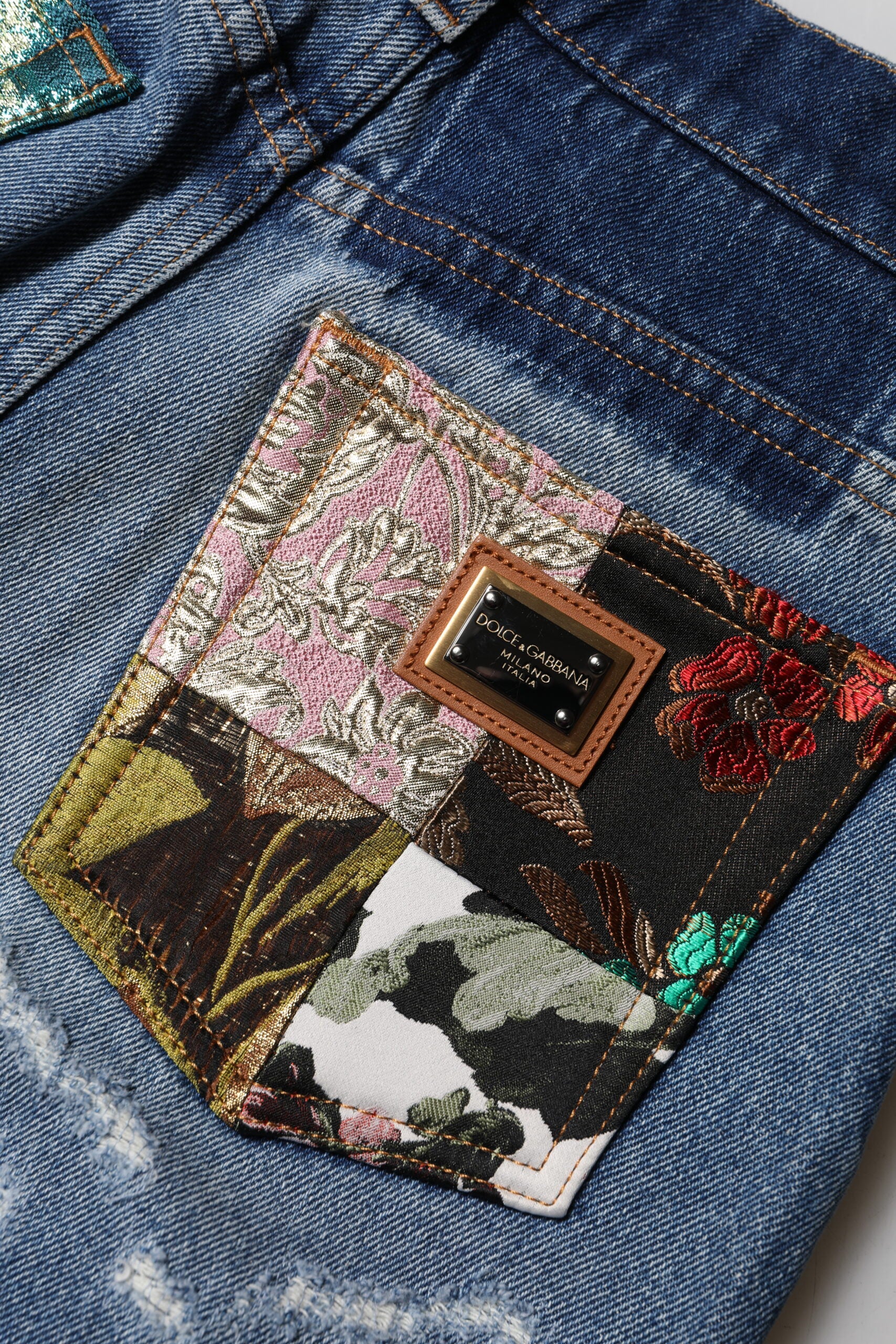 Jeans en denim bleu Dolce & Gabbana, taille haute, déchirés, style vintage, en coton, visible sur l'image.