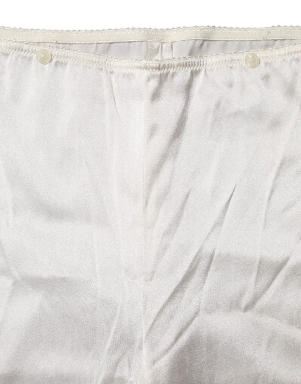 Pantalon en soie ivoire à taille haute et coupe tapered, de la marque Dolce & Gabbana, présenté sur un fond neutre.