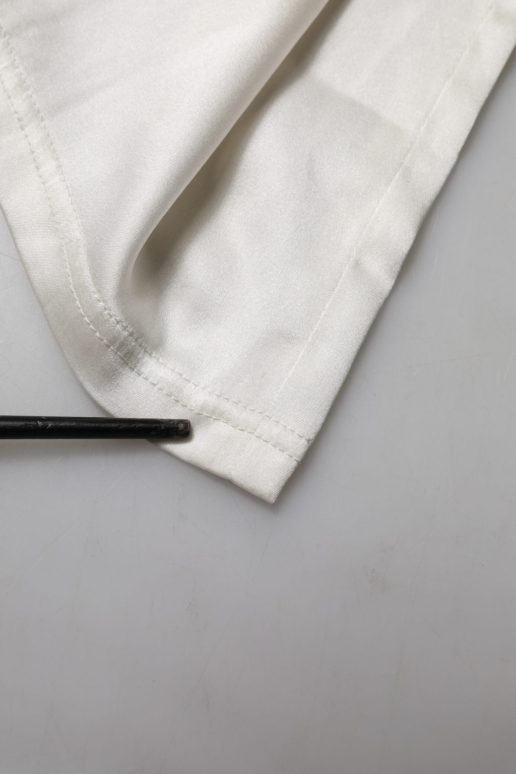 Pantalons en soie ivoire à taille haute et coupe tapered de Dolce & Gabbana, vue de face.