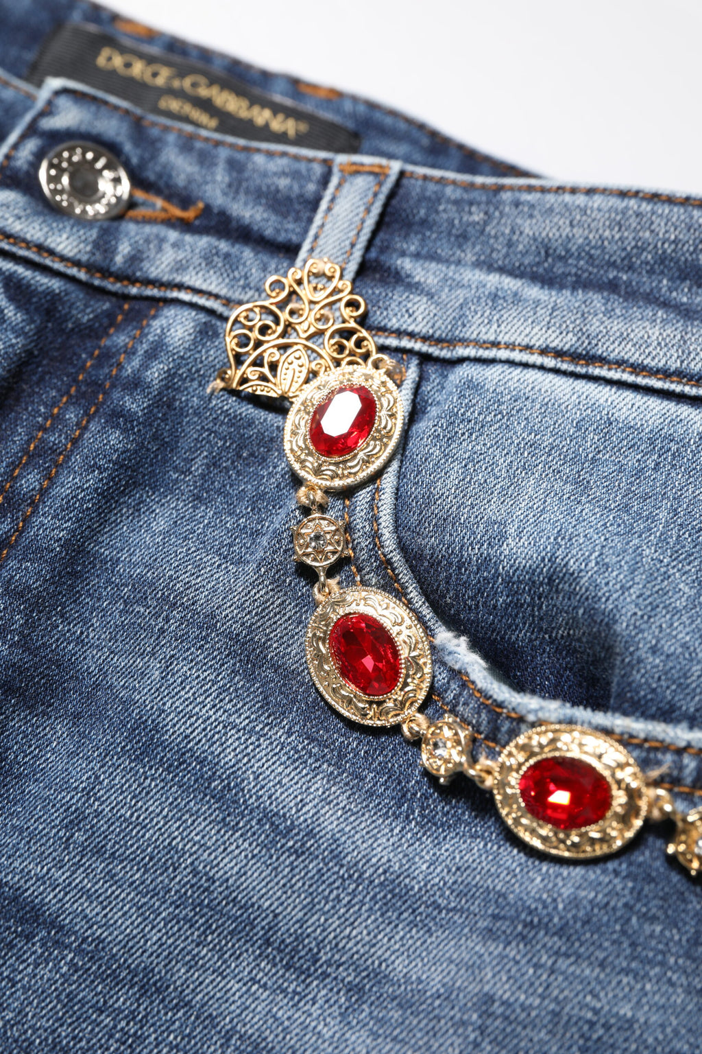 Jeans en denim bleu Dolce & Gabbana avec embellissements en strass, style tendance et détails brillants visibles sur l'image.