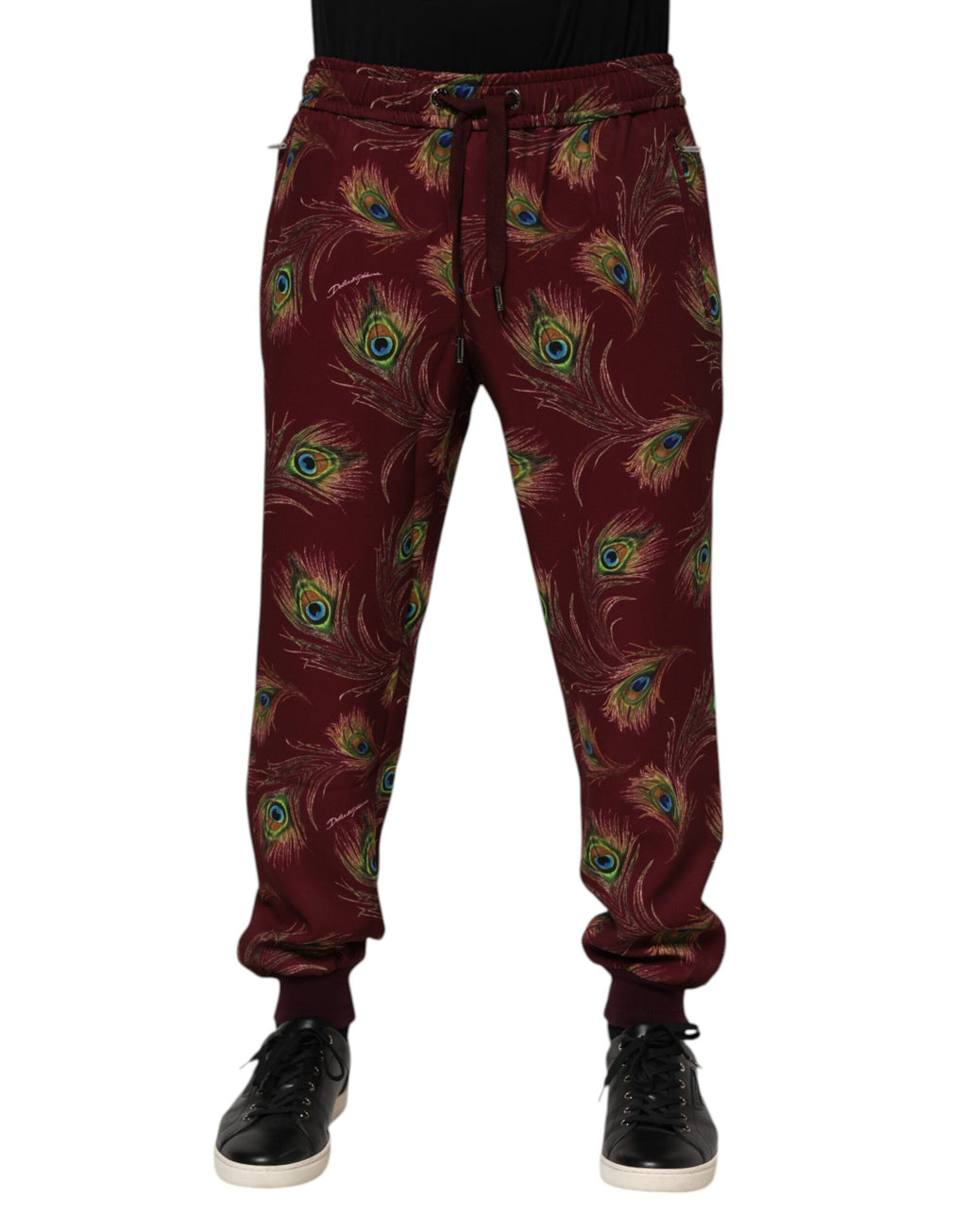 Pantalons de jogging Dolce & Gabbana en velours bordeaux avec motif plumes de paon, style décontracté et élégant.