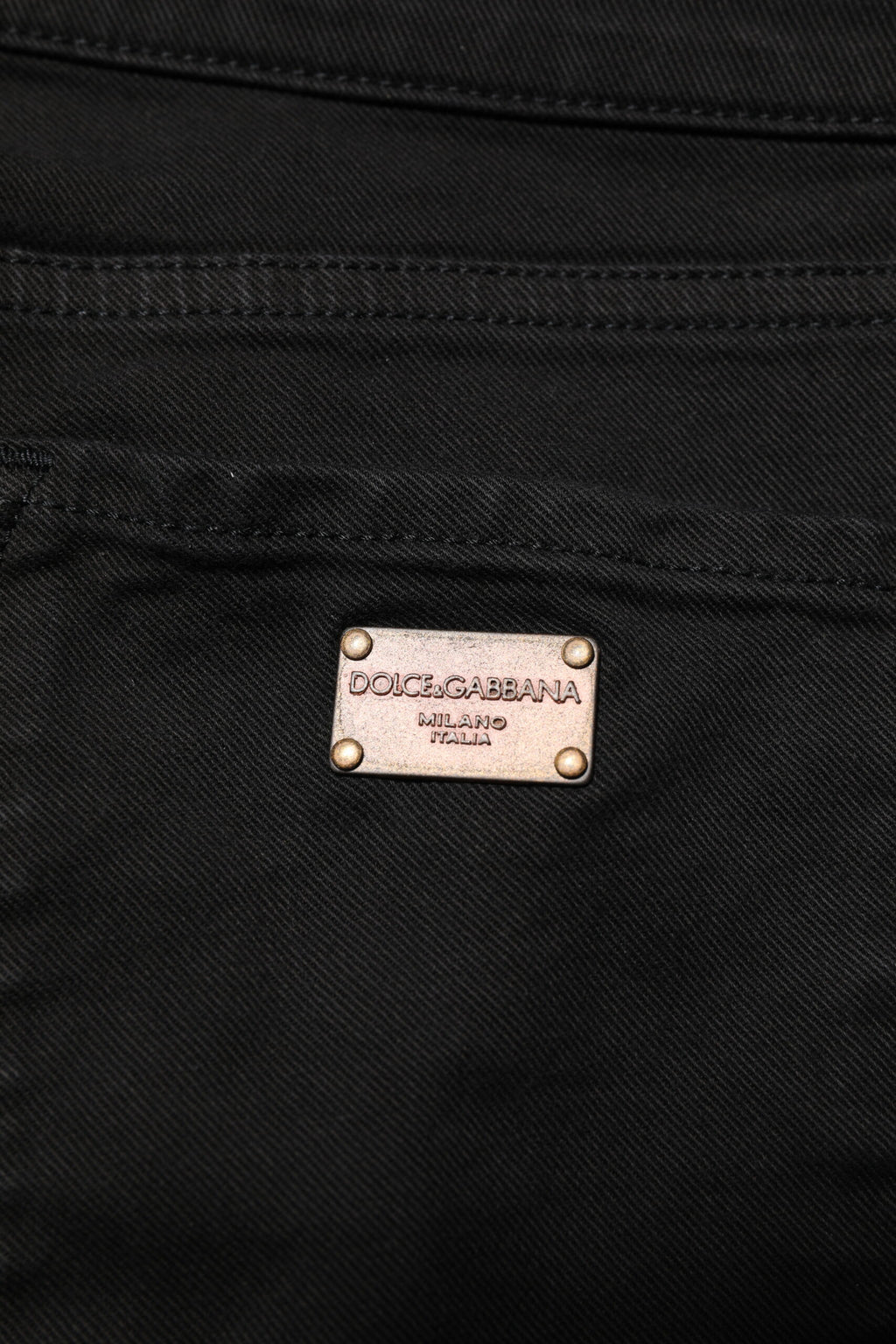 Jeans skinny en coton noir Dolce & Gabbana avec logo, taille moyenne, coupe ajustée et design moderne visible sur l'image.