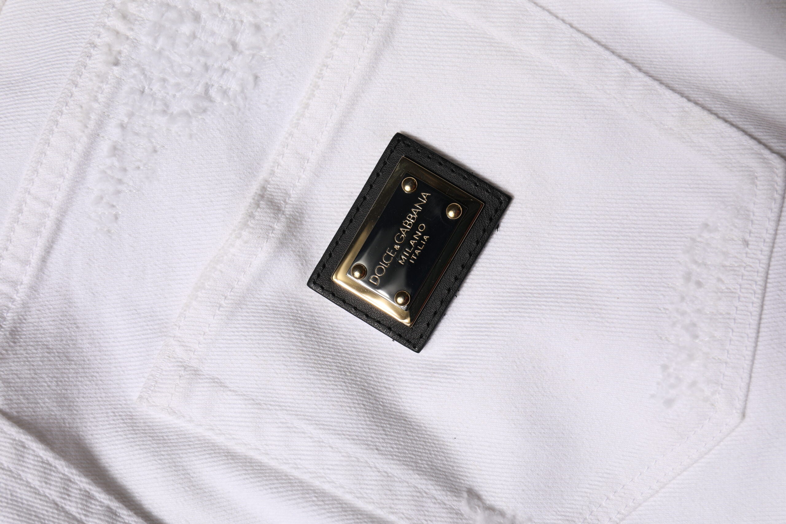 Jeans en denim blanc déchiré à taille haute de Dolce & Gabbana, style décontracté et tendance, vue de face.
