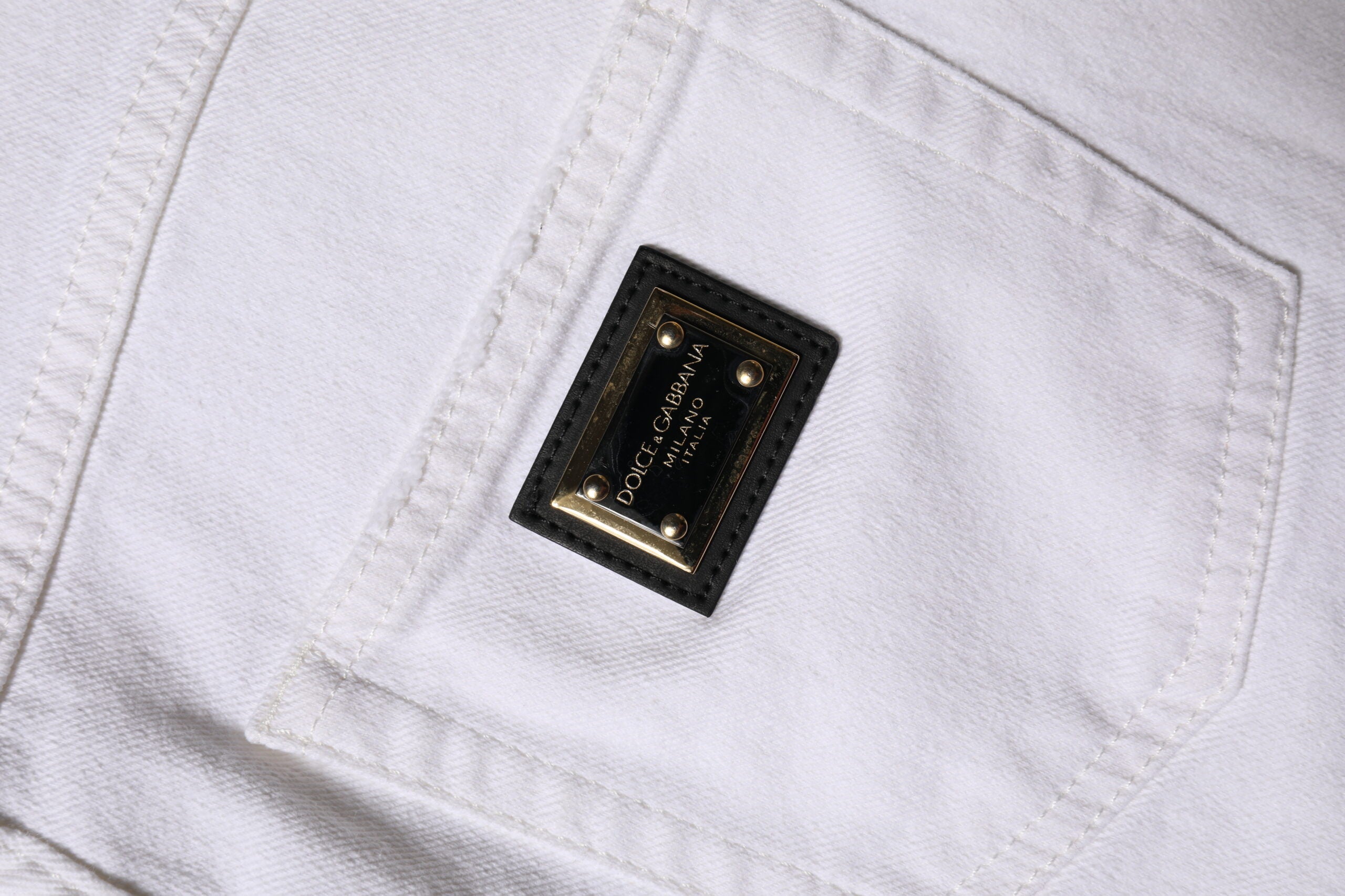 Jeans en denim blanc Dolce & Gabbana à taille haute et coupe droite, vue de face, en coton.