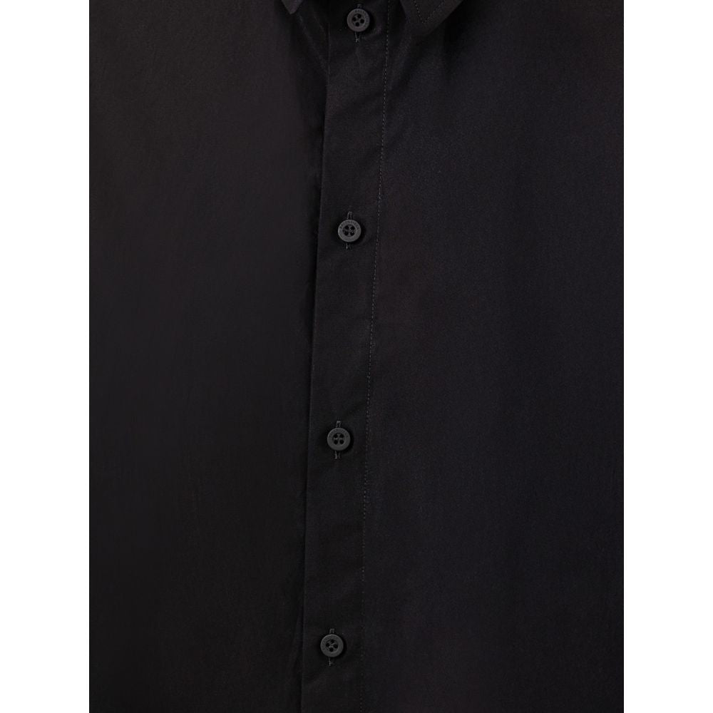 Robe longue noire en coton de Balenciaga, élégante et fluide, portée avec un style sophistiqué et moderne.