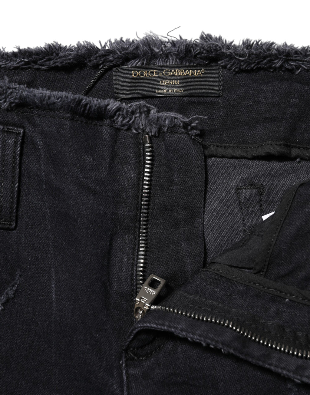 Jeans skinny en coton noir tacheté de Dolce & Gabbana, style déchiré et tendance, visibles sur l'image.