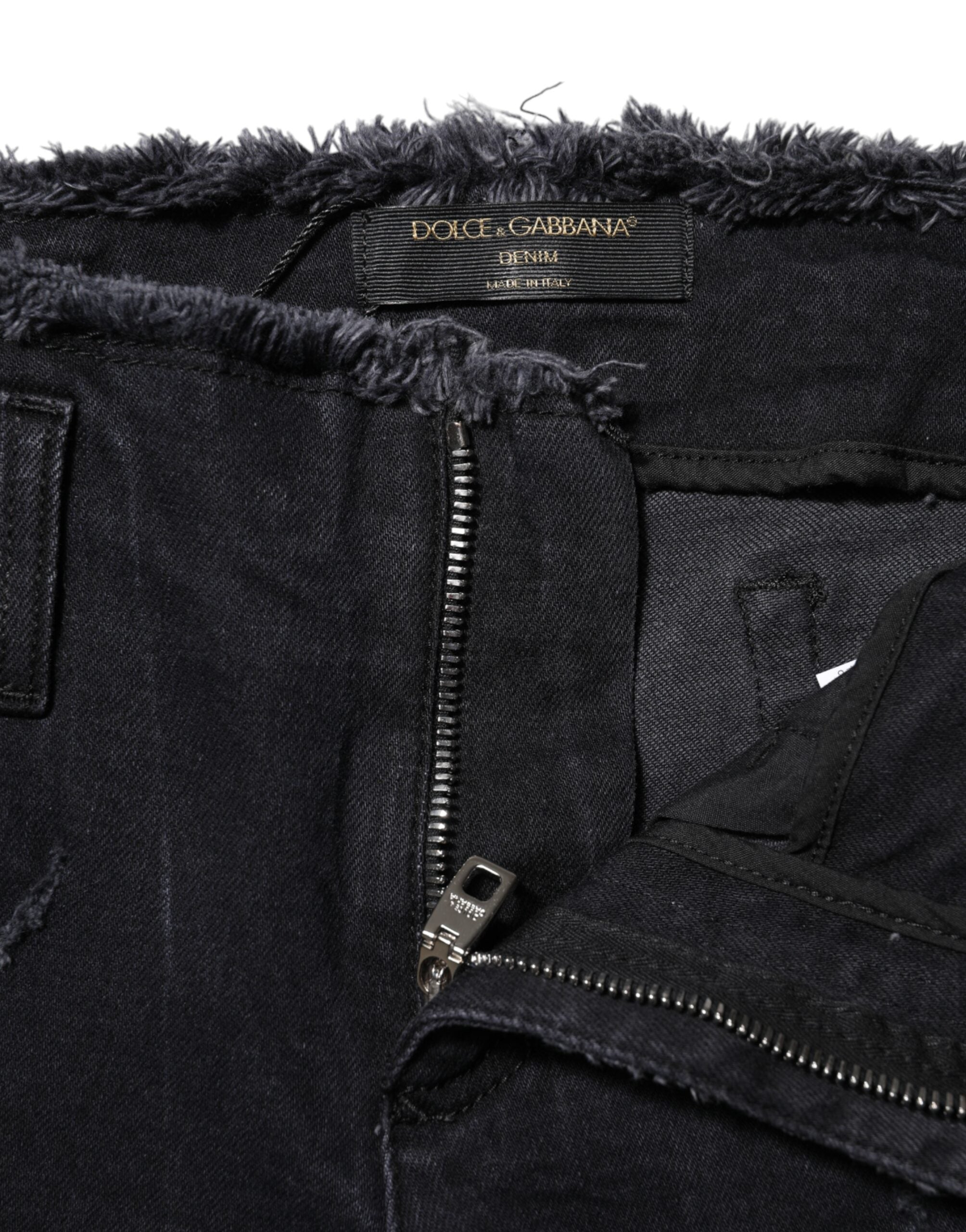 Jeans skinny en coton noir tacheté de Dolce & Gabbana, style déchiré et tendance, visibles sur l'image.
