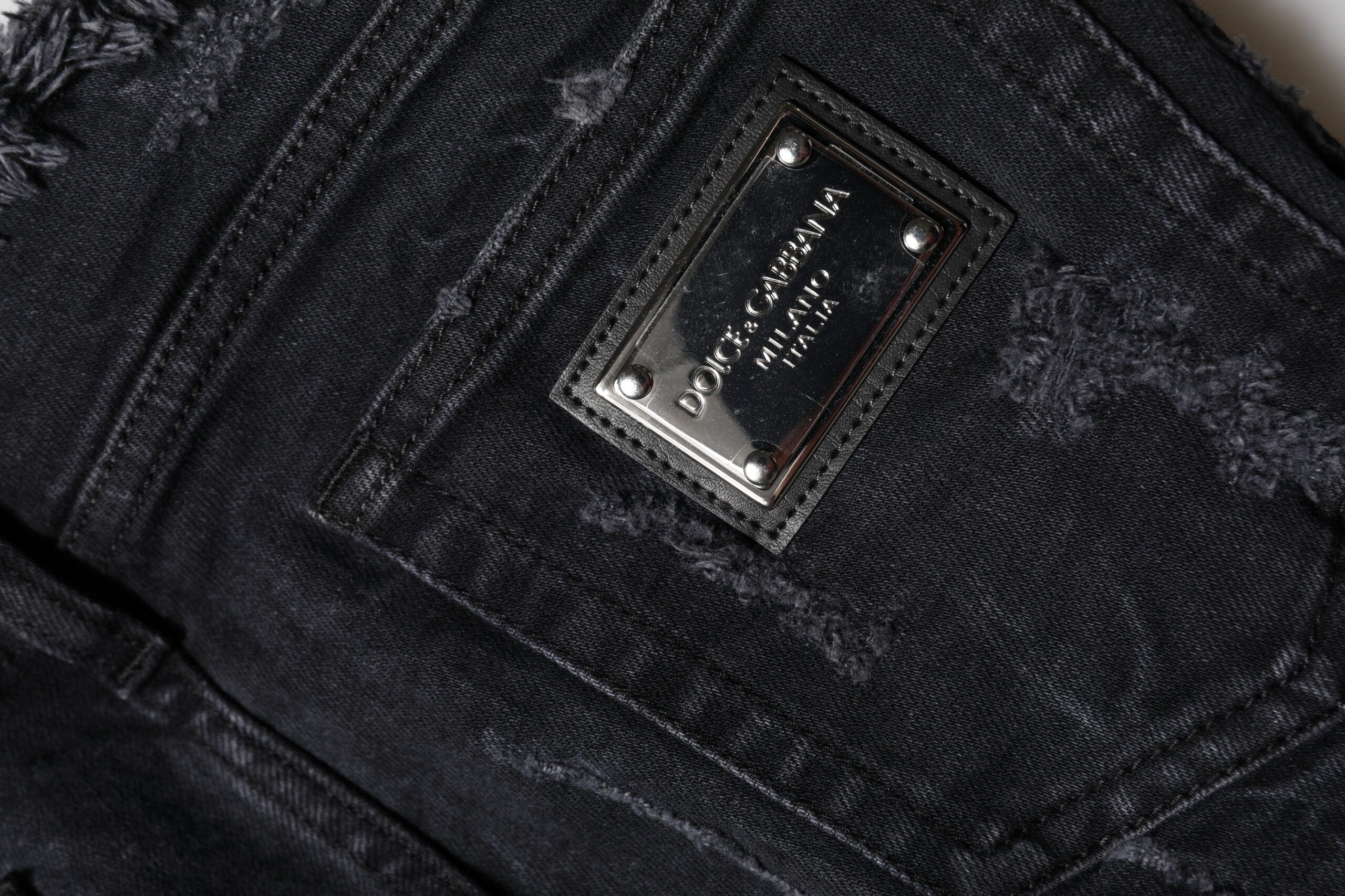Jeans skinny en denim noir Dolce & Gabbana en coton avec déchirures et ourlets tachetés, style décontracté et tendance.