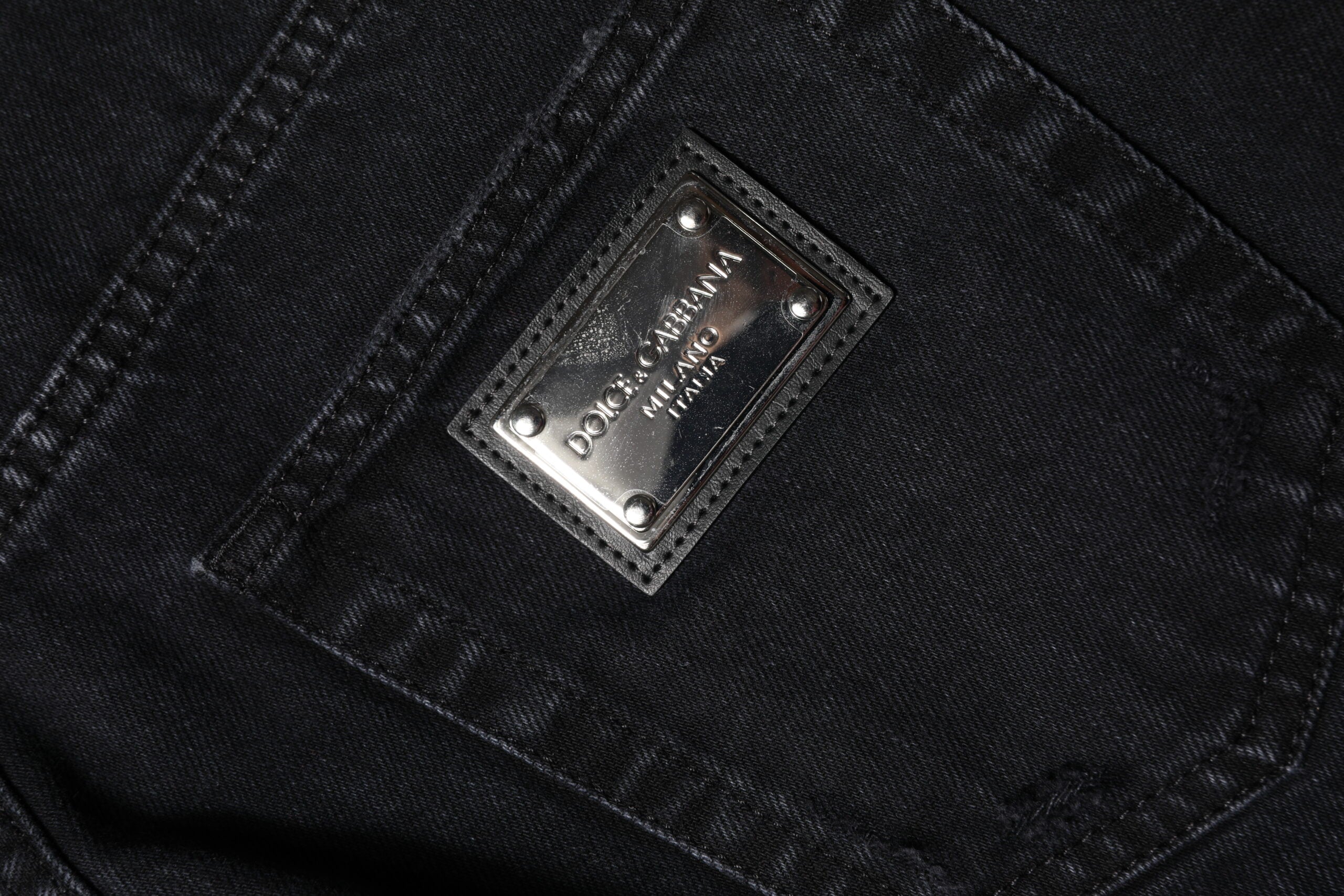 Jeans déchirés en coton noir de Dolce & Gabbana, coupe mi-haute, style décontracté et tendance.
