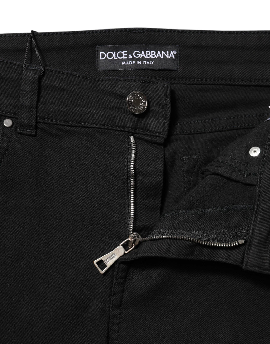 Jeans slim en coton noir Dolce & Gabbana avec logo, taille mi-haute, style denim ajusté, visible sur l'image.