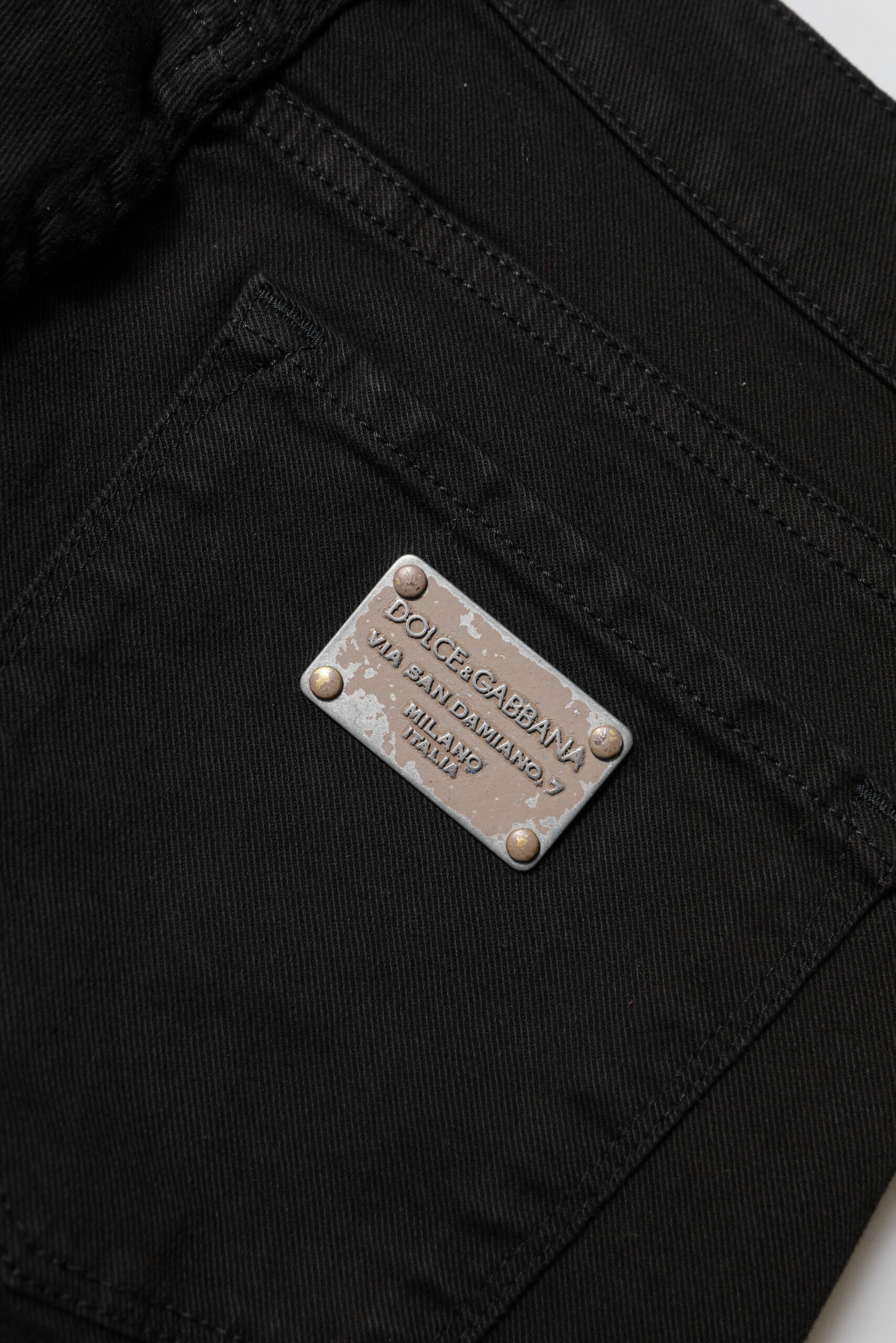 Jeans skinny en coton noir Dolce & Gabbana avec logo, taille mi-hauteur et coupe ajustée, visibles sur l'image.