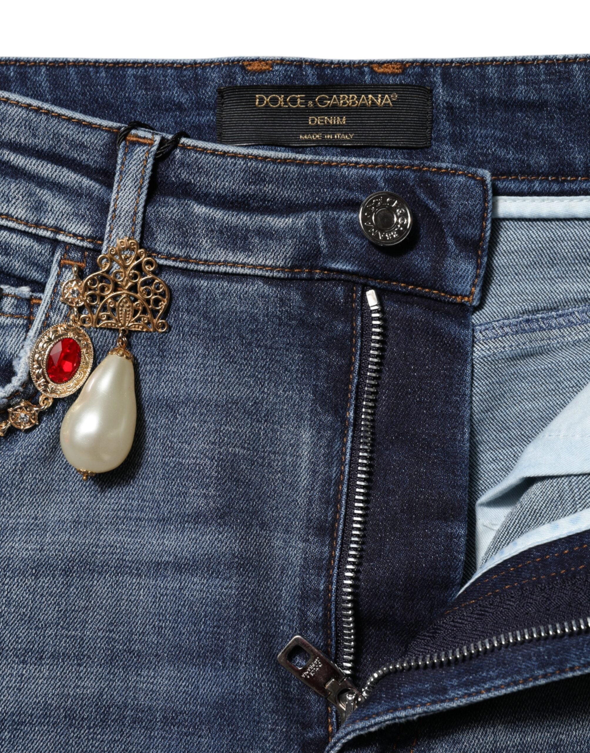 Jeans en denim Dolce & Gabbana ornés de strass bleus et de détails brillants, vue de face avec fermeture éclair et poches.