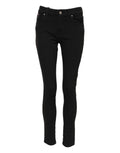 Jeans slim en coton noir Dolce & Gabbana avec logo, taille mi-haute, coupe ajustée, visibles sur le mannequin.