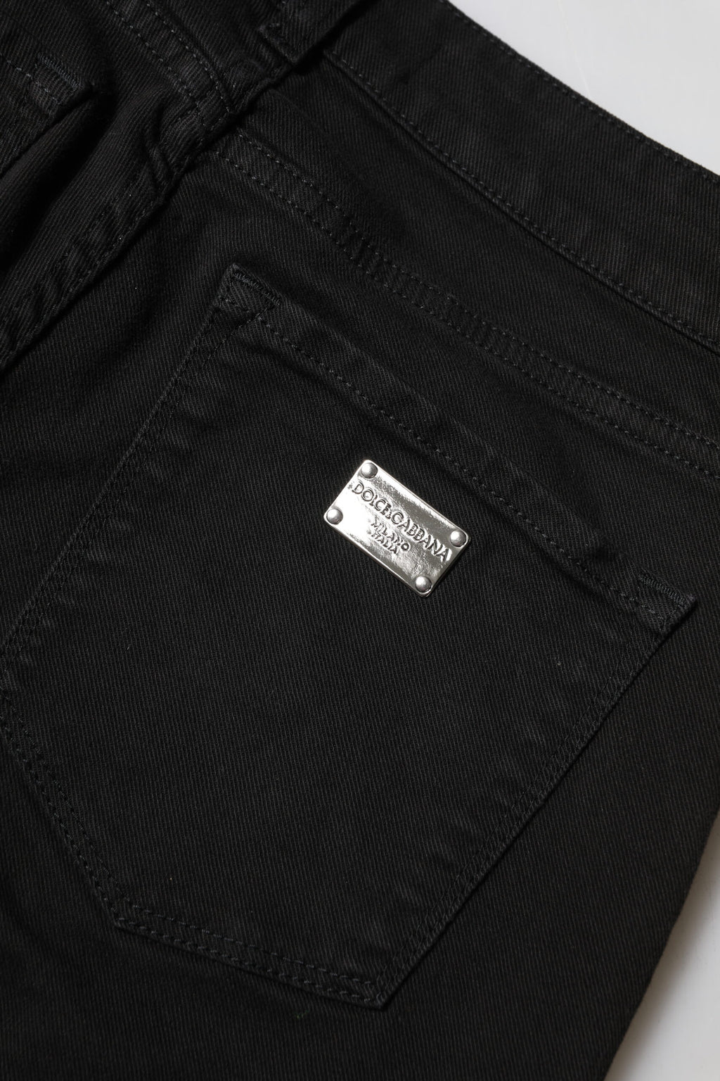 Jeans skinny en coton noir Dolce & Gabbana avec logo, taille mi-haute, denim tendance, visible sur l'image.