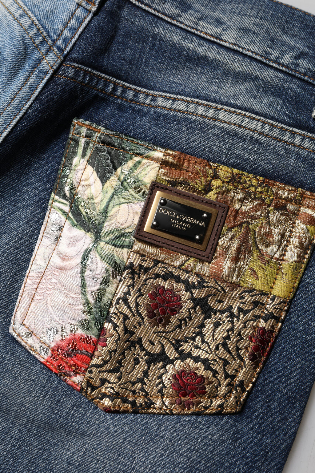 Jeans en denim tacheté en patchwork multicolore de Dolce & Gabbana, coupe tapered, mode urbaine et élégante.