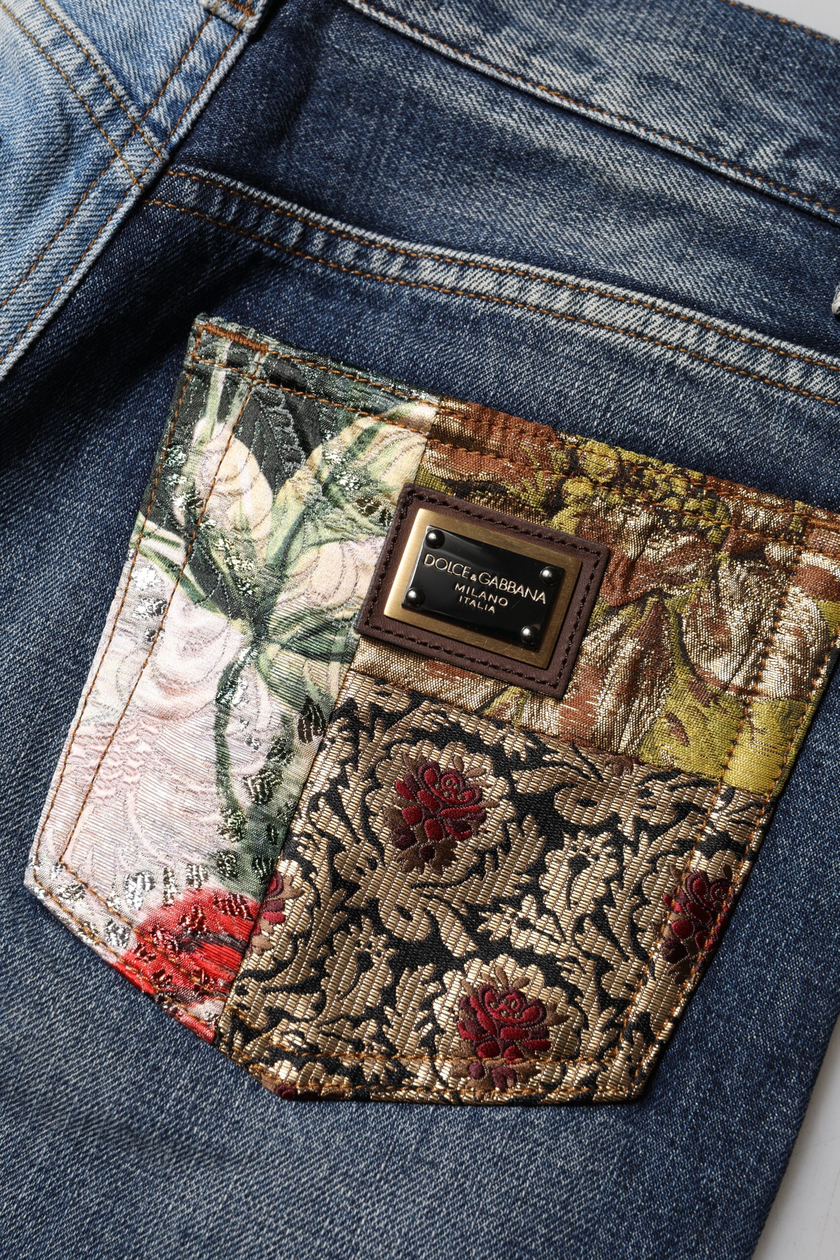 Jeans en denim tacheté en patchwork multicolore de Dolce & Gabbana, coupe tapered, mode urbaine et élégante.