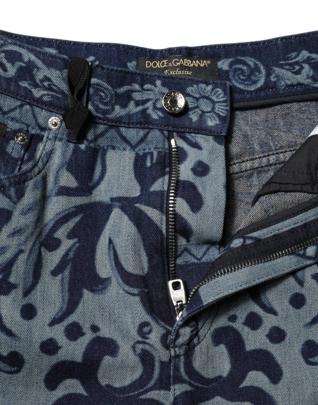 Jeans en denim bleu Dolce & Gabbana à coupe tapered avec motif graphique, visibles avec détails de couture et design moderne.