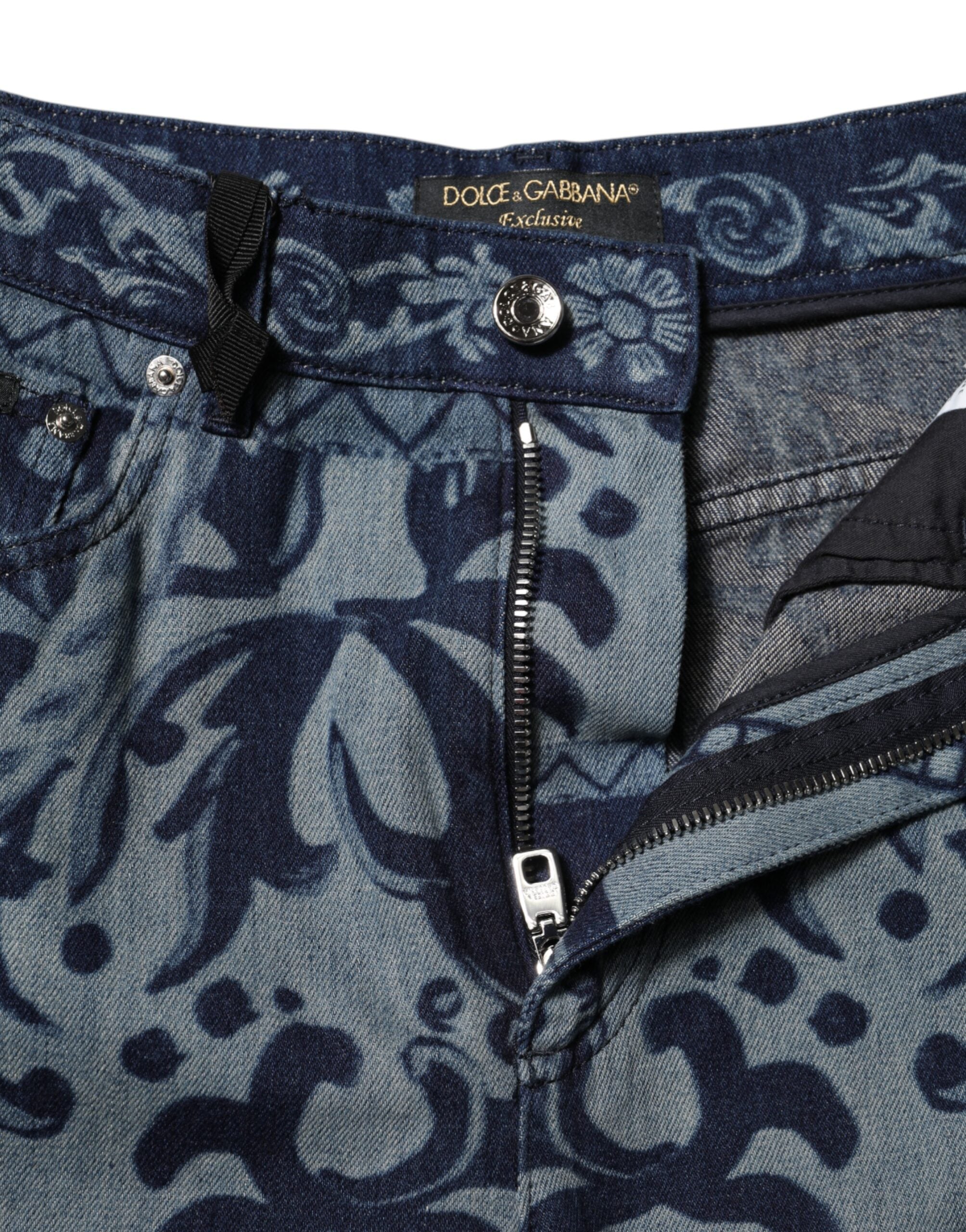 Jeans en denim bleu Dolce & Gabbana à coupe tapered avec motif graphique, visibles avec détails de couture et design moderne.