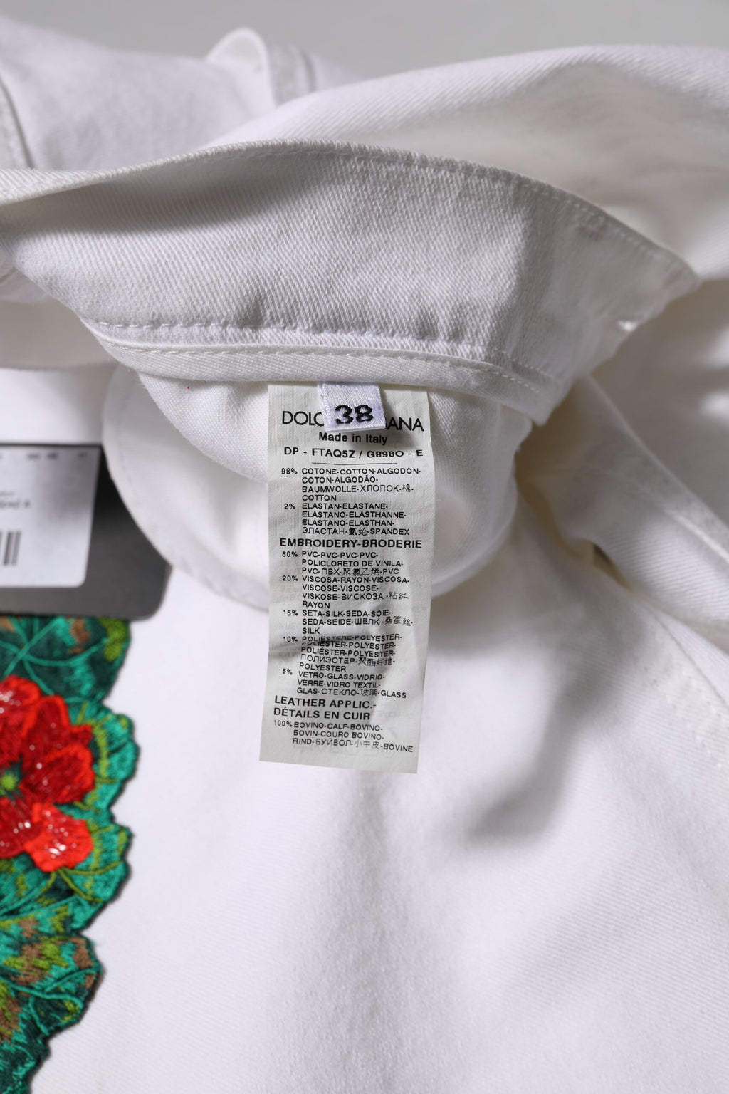 Jeans en denim blanc Dolce & Gabbana avec broderie florale, style féminin et tendance, visible dans l'image.