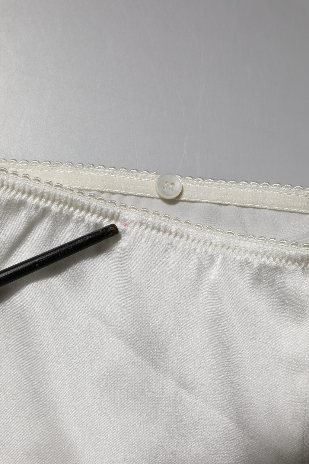 Pantalons en soie ivoire à taille haute et coupe tapered par Dolce & Gabbana, élégants et sophistiqués.