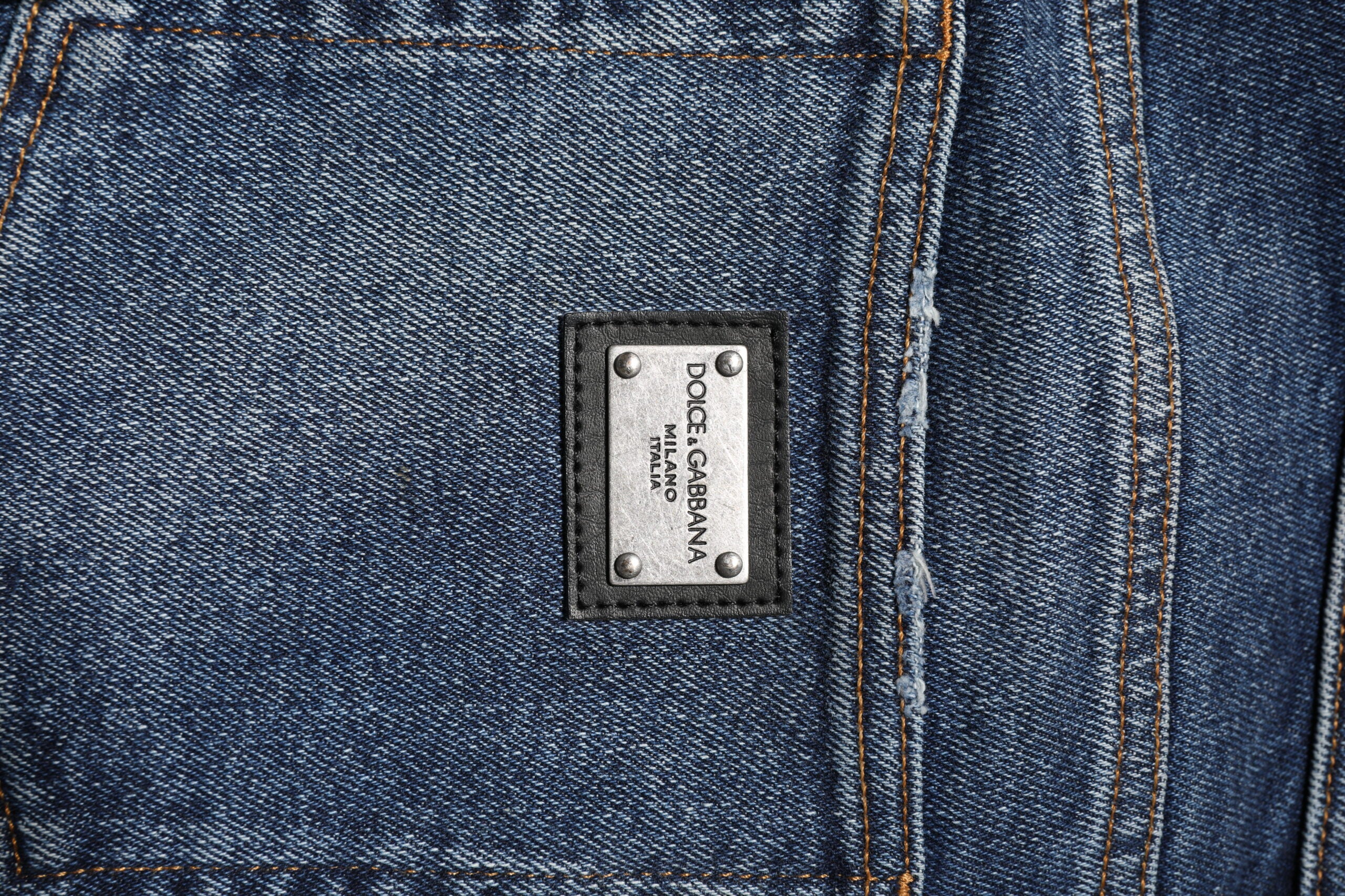 Jeans en denim bleu coton Dolce & Gabbana, taille moyenne, coupe droite, visibles sur le mannequin.