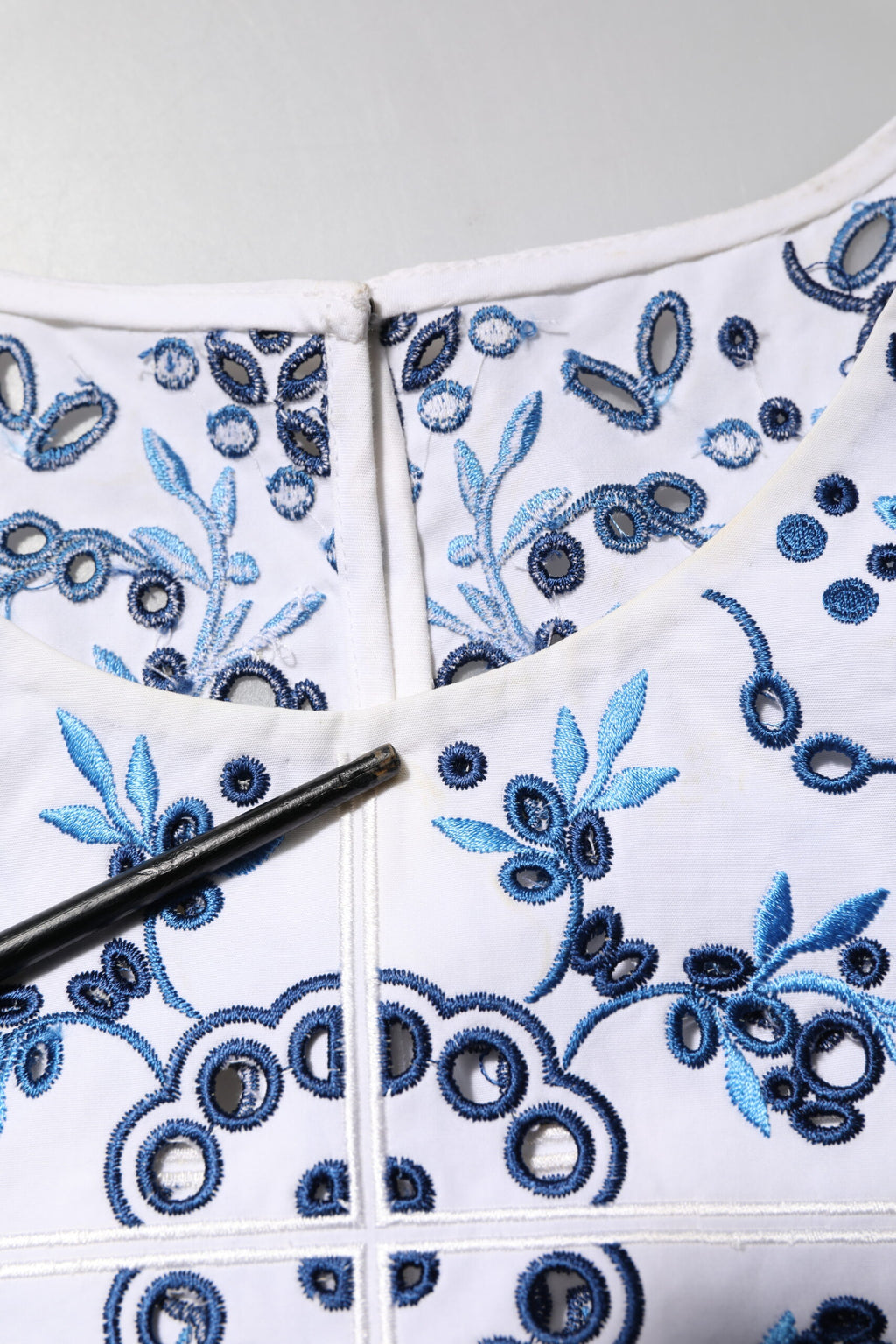 Blouse Dolce & Gabbana en dentelle bleue avec col rond en broderie, manches longues élégantes.