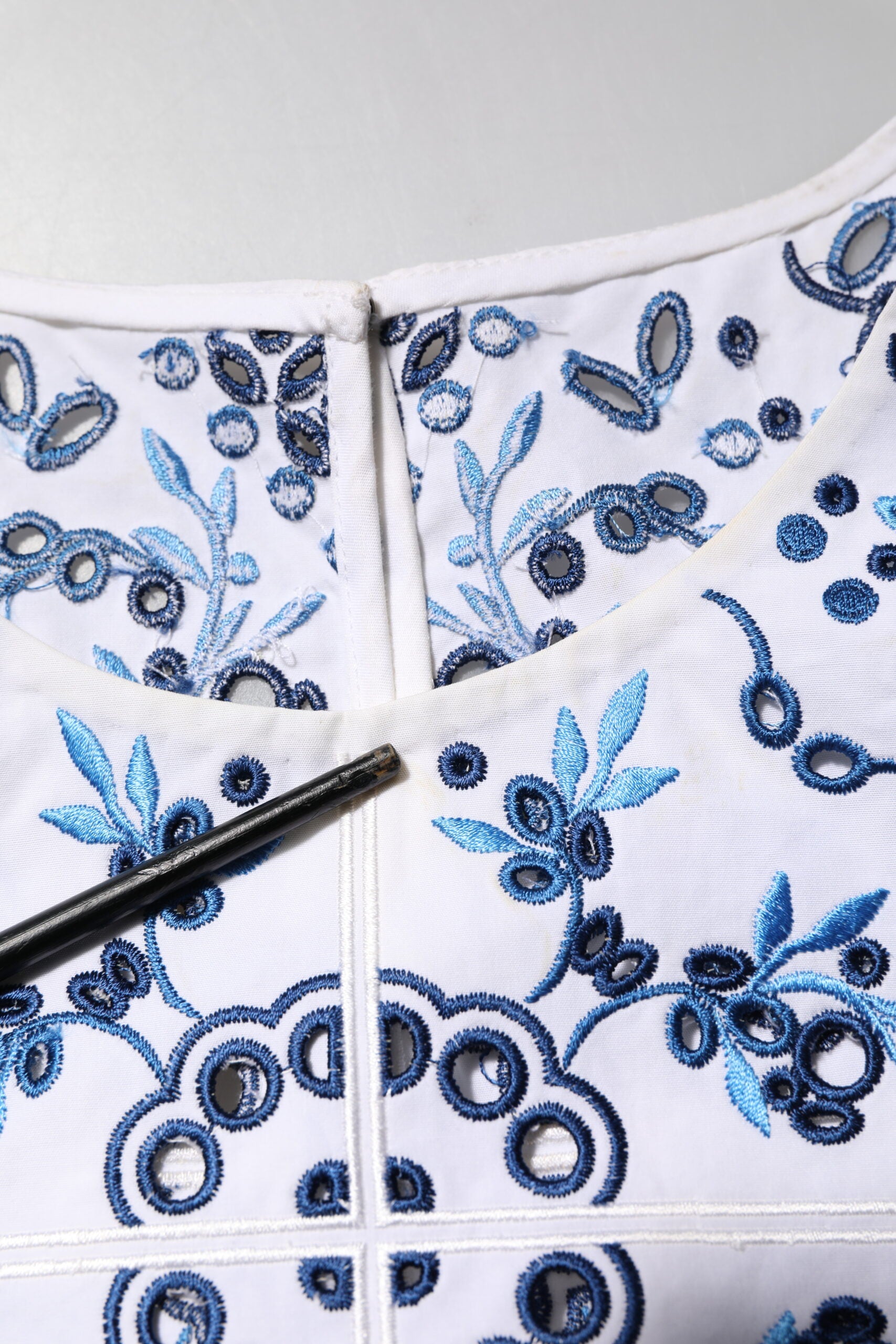 Blouse Dolce & Gabbana en dentelle bleue avec col rond en broderie, manches longues élégantes.
