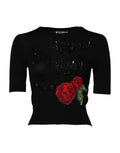 Chemisier noir Dolce & Gabbana avec broderies de roses en sequins, détails élégants et tissu fluide visible sur l'image.