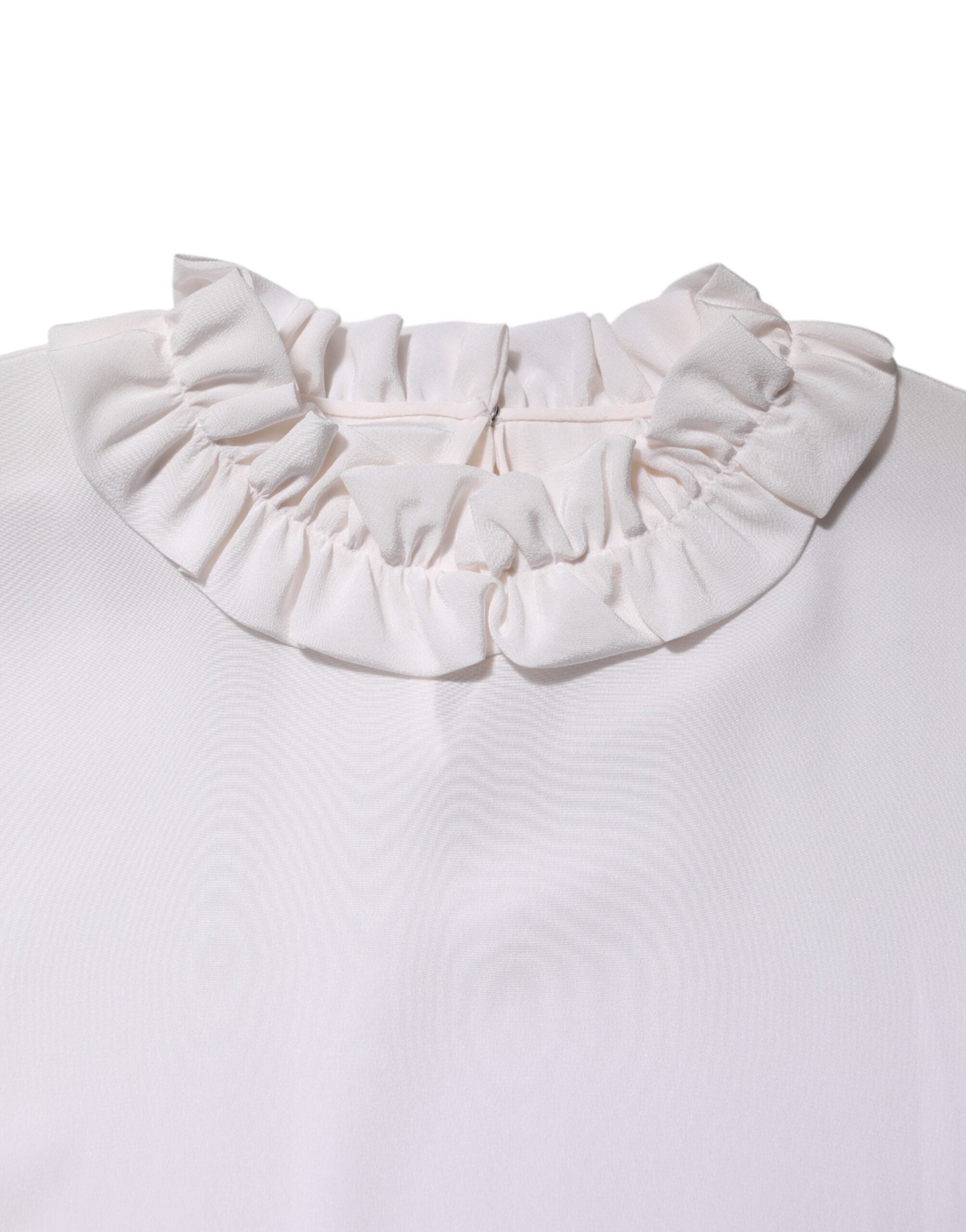Blouse blanche Dolce & Gabbana à col volanté avec détails froncés, tissu léger, style élégant et féminin.