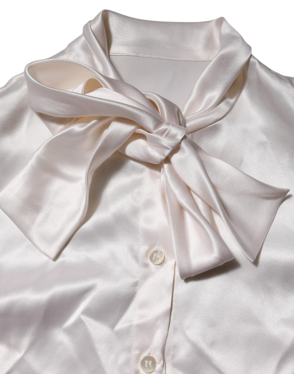 Chemisier blanc à col ascot Dolce & Gabbana à manches longues, élégant et sophistiqué, visible en détail.